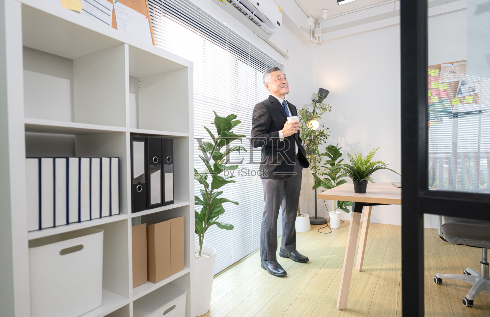 在现代办公室，老板在会议前喝咖啡以检查商业项目的进展。照片摄影图片