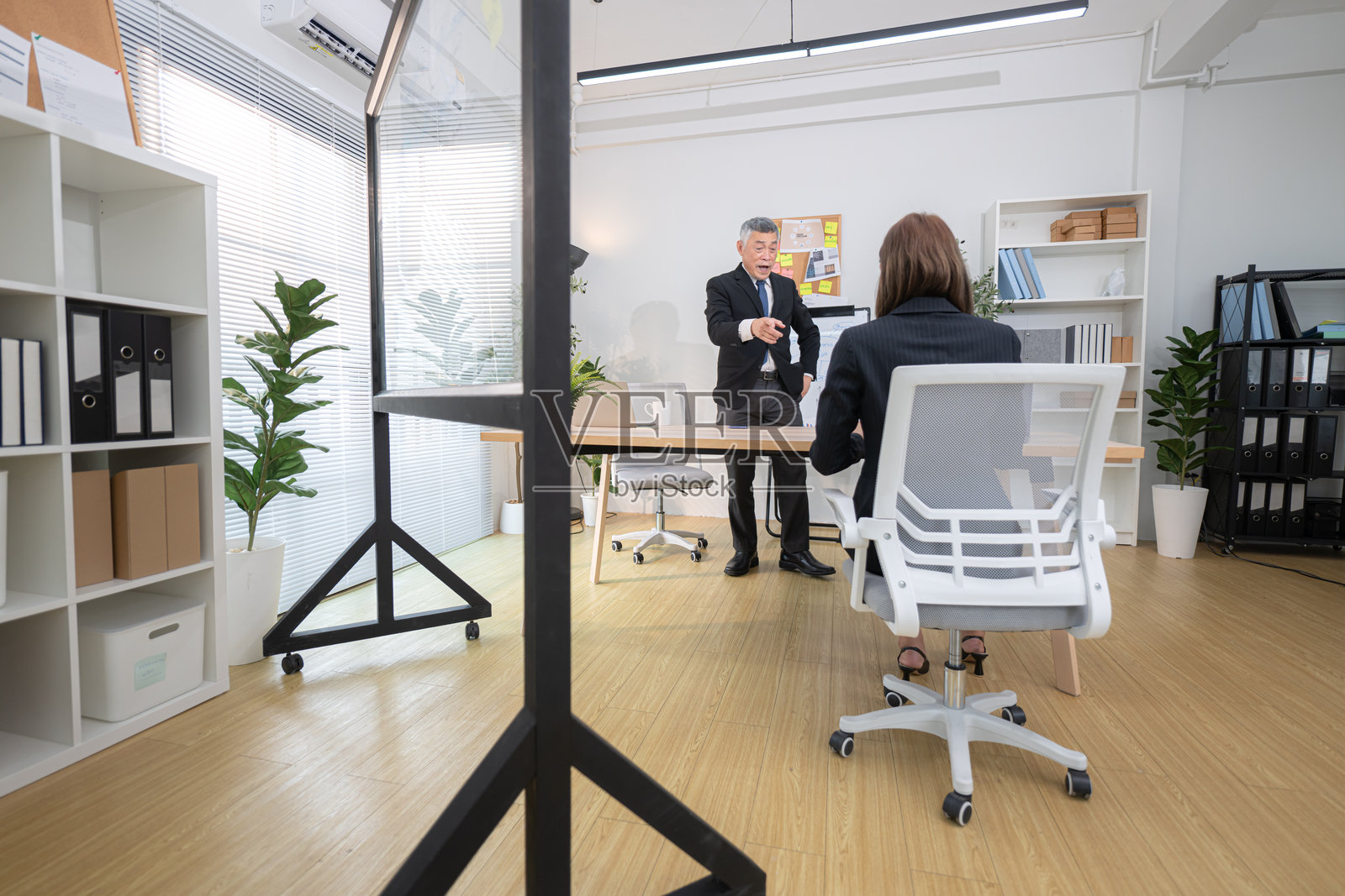 在现代办公室，老板和助理正在监控一个商业项目的进展。照片摄影图片