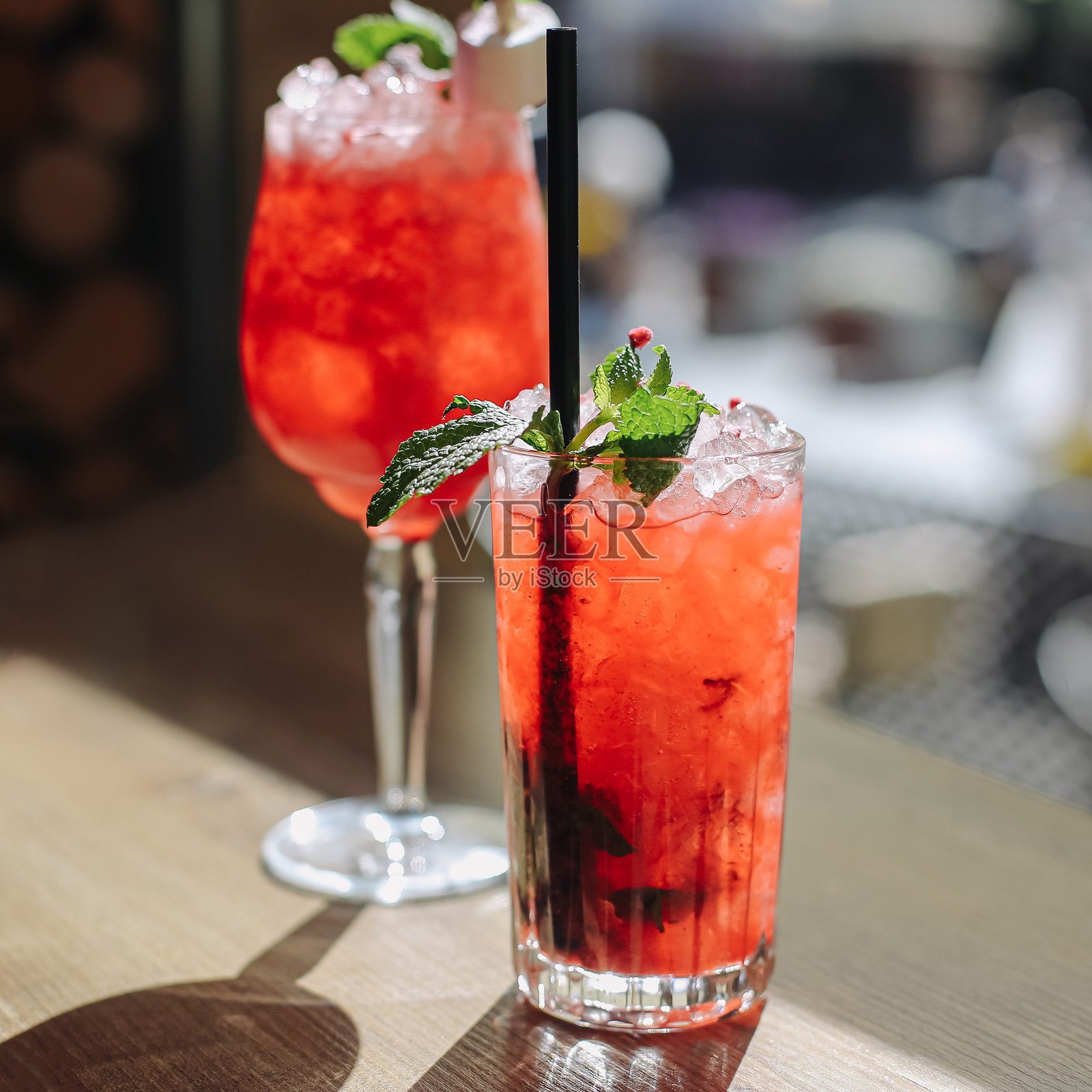 红色鸡尾酒配薄荷。夏季饮品清爽。酒杯中的酒精饮料。酒吧台上的特写。照片摄影图片