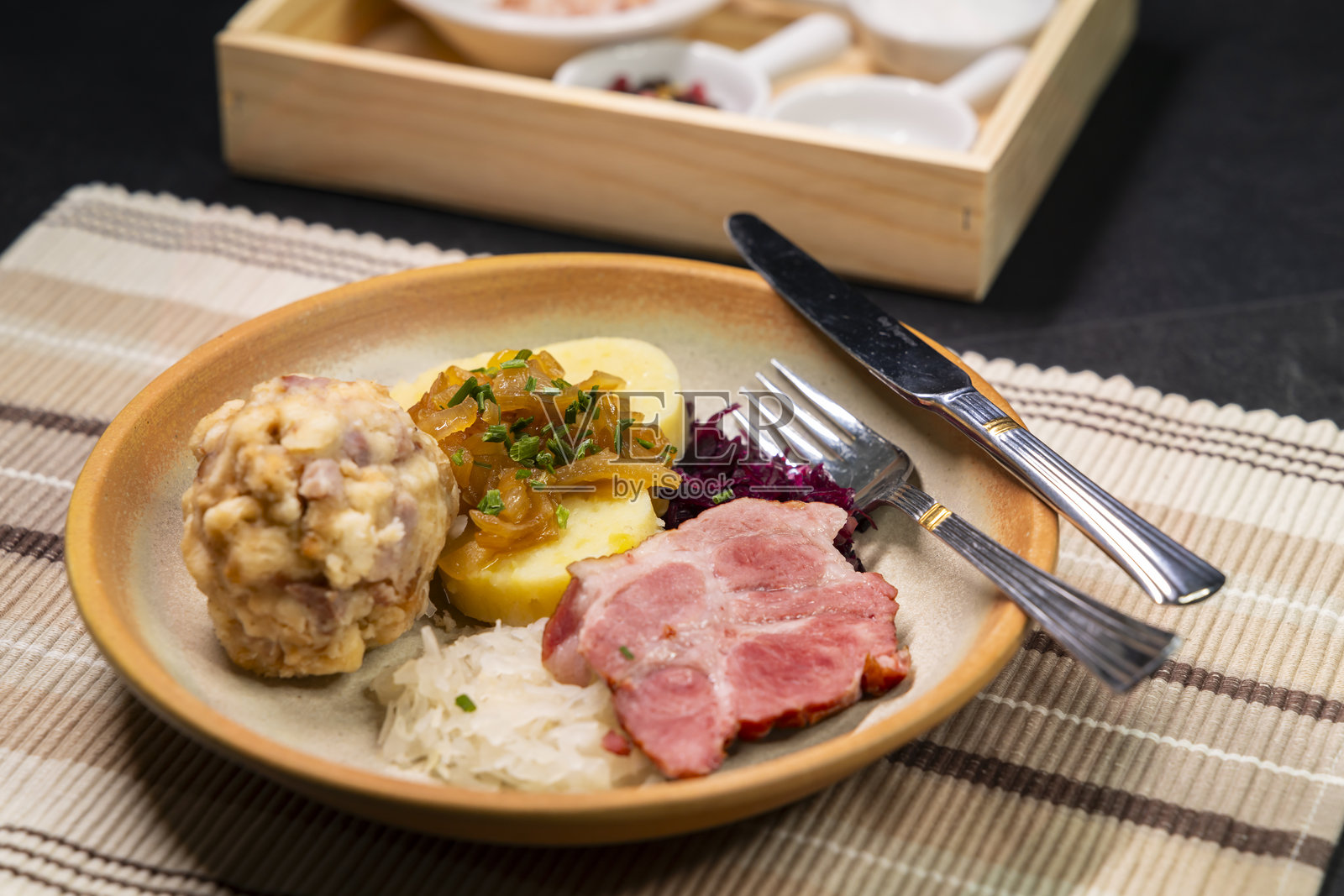 巴伐利亚饺子配烤猪肉、酸菜和土豆饺子，摆放在盘子上照片摄影图片