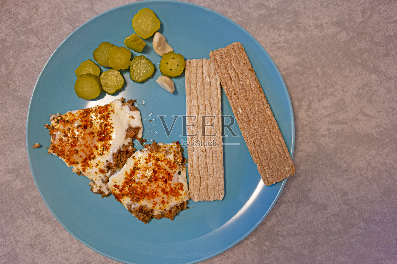 盘子上的煎蛋和新鲜蔬菜，背景为石灰灰色，体现健康饮食理念。照片摄影图片