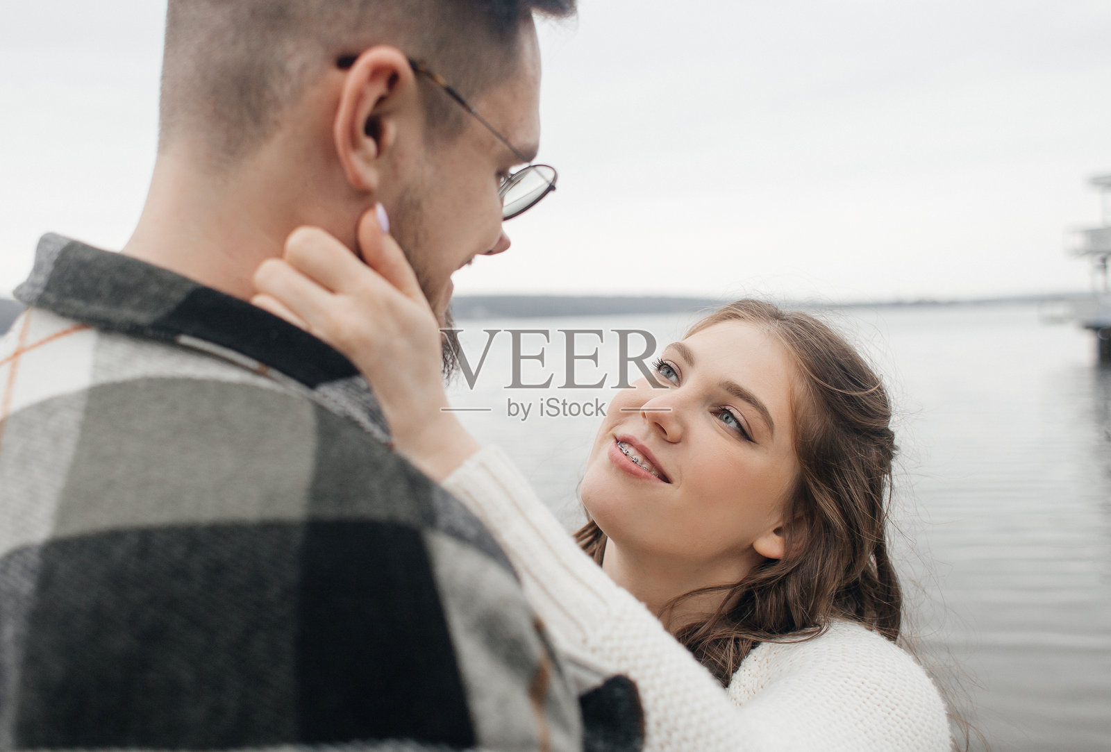 带牙套的微笑。一个带牙套的美丽女孩在约会。年轻人们在跳舞、亲吻和拥抱，享受相聚的时光。照片摄影图片