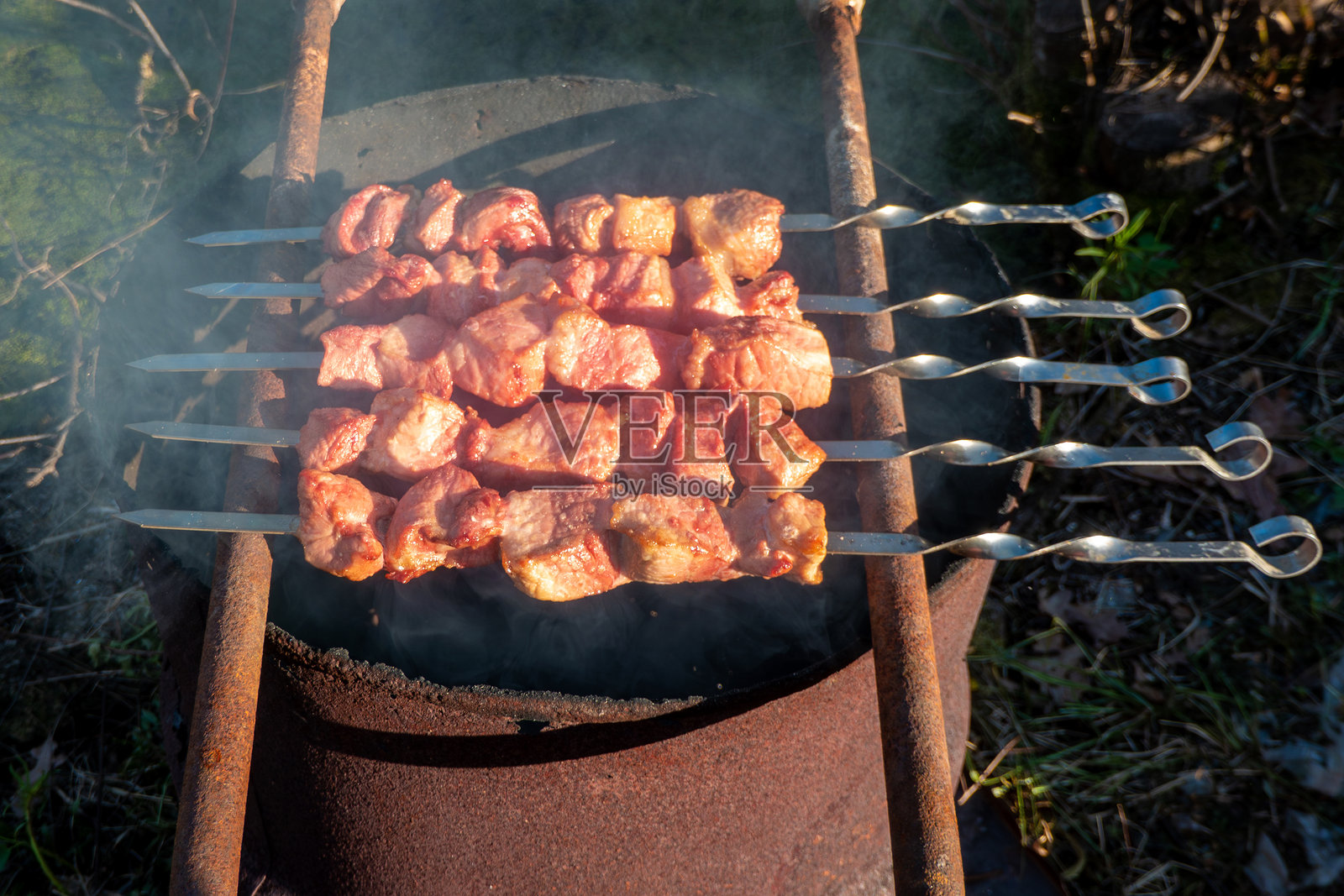 用于烤牛肉的桶，桶口冒出大量白烟，散发着美味的香气。照片摄影图片