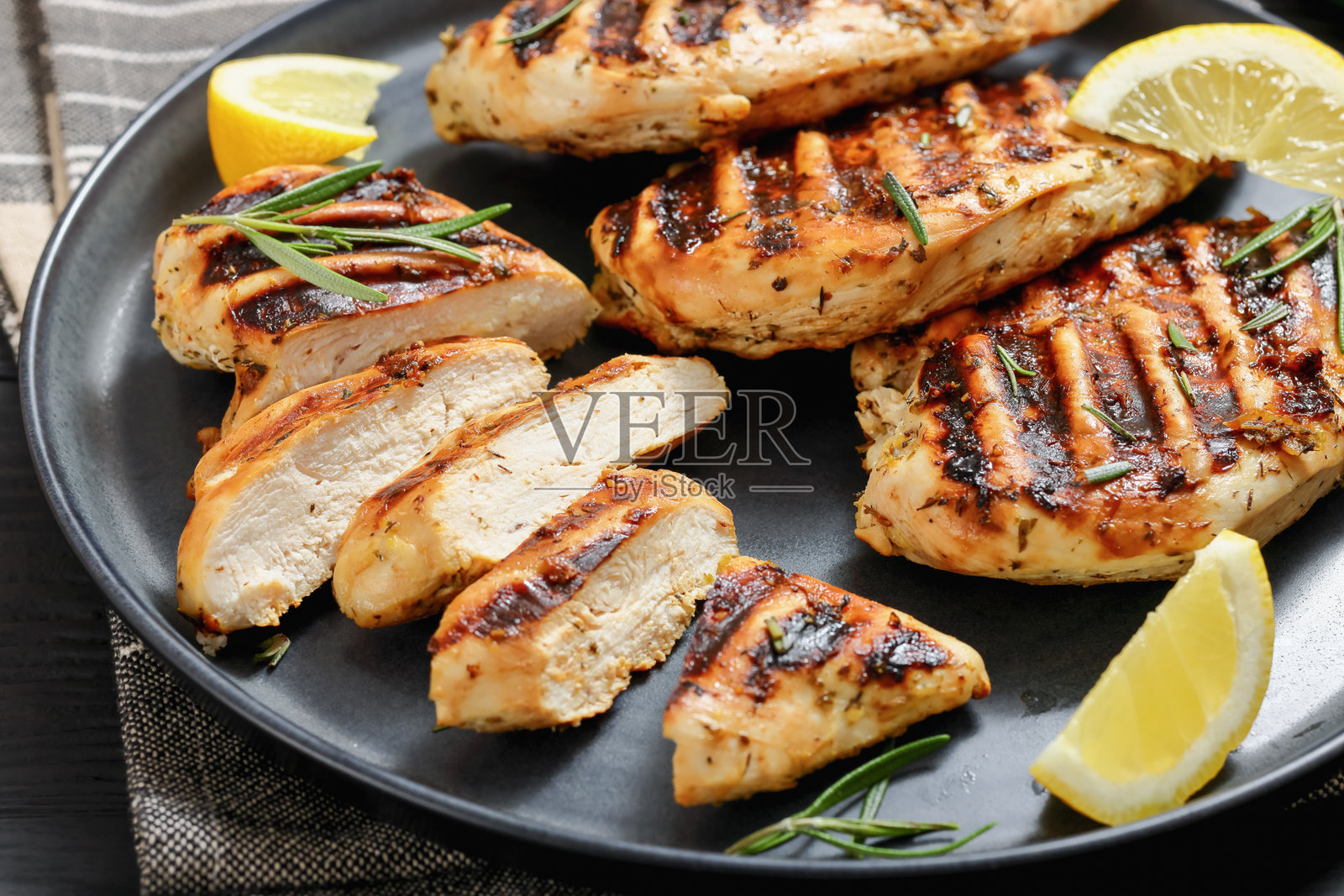 盘子上的柠檬烤鸡胸肉照片摄影图片
