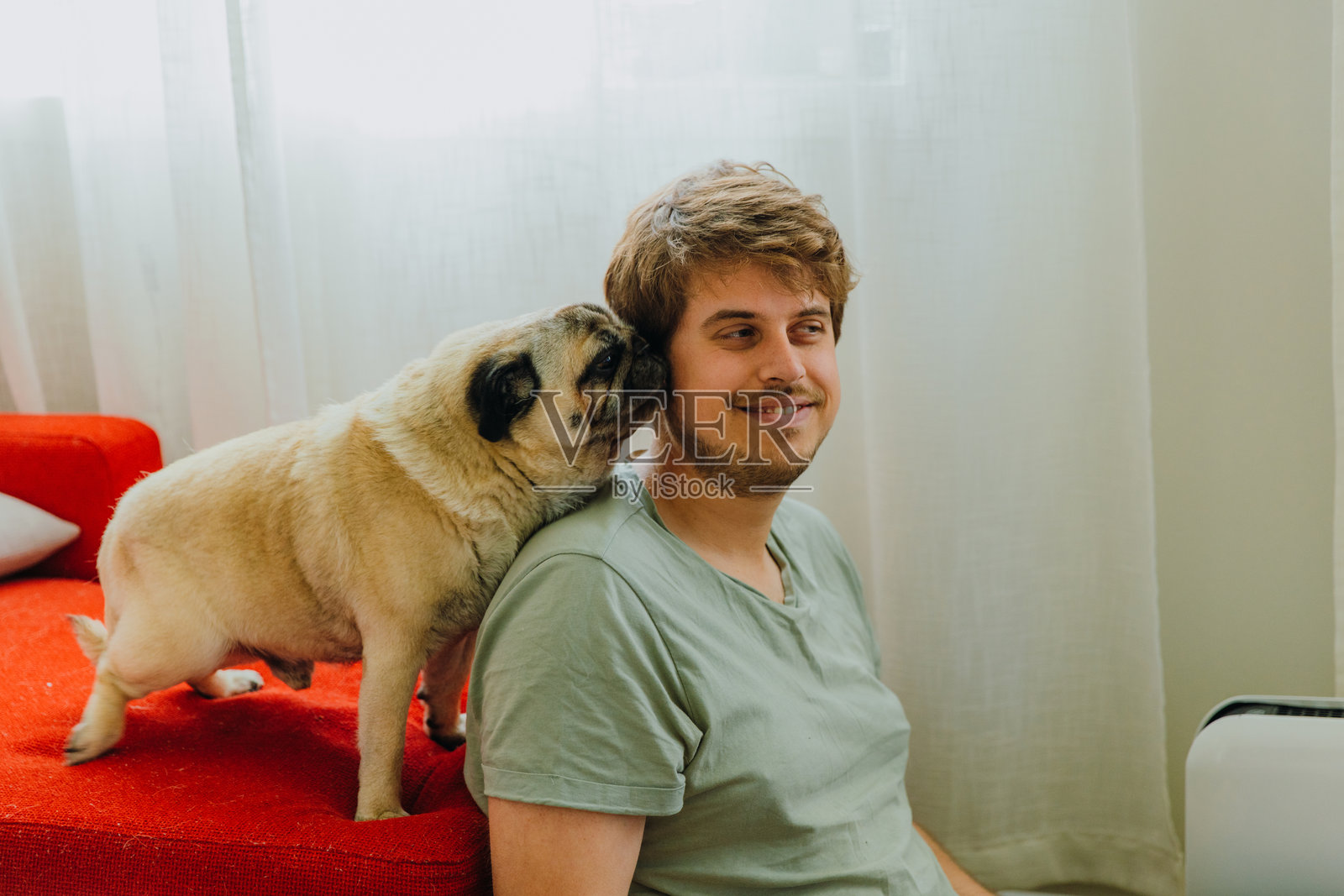 微笑的男人在家放松，享受与他的狗在一起的时光照片摄影图片