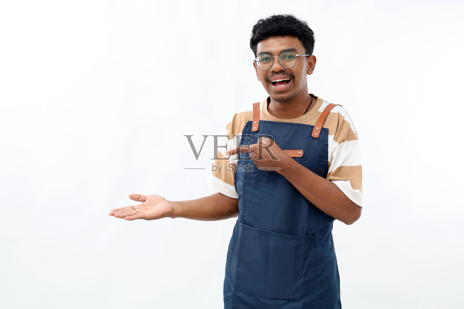 烹饪、烹饪艺术和人们的概念，快乐微笑的男人穿着围裙，空着的手上好像拿着什么想象中的东西，背景为白色。照片摄影图片