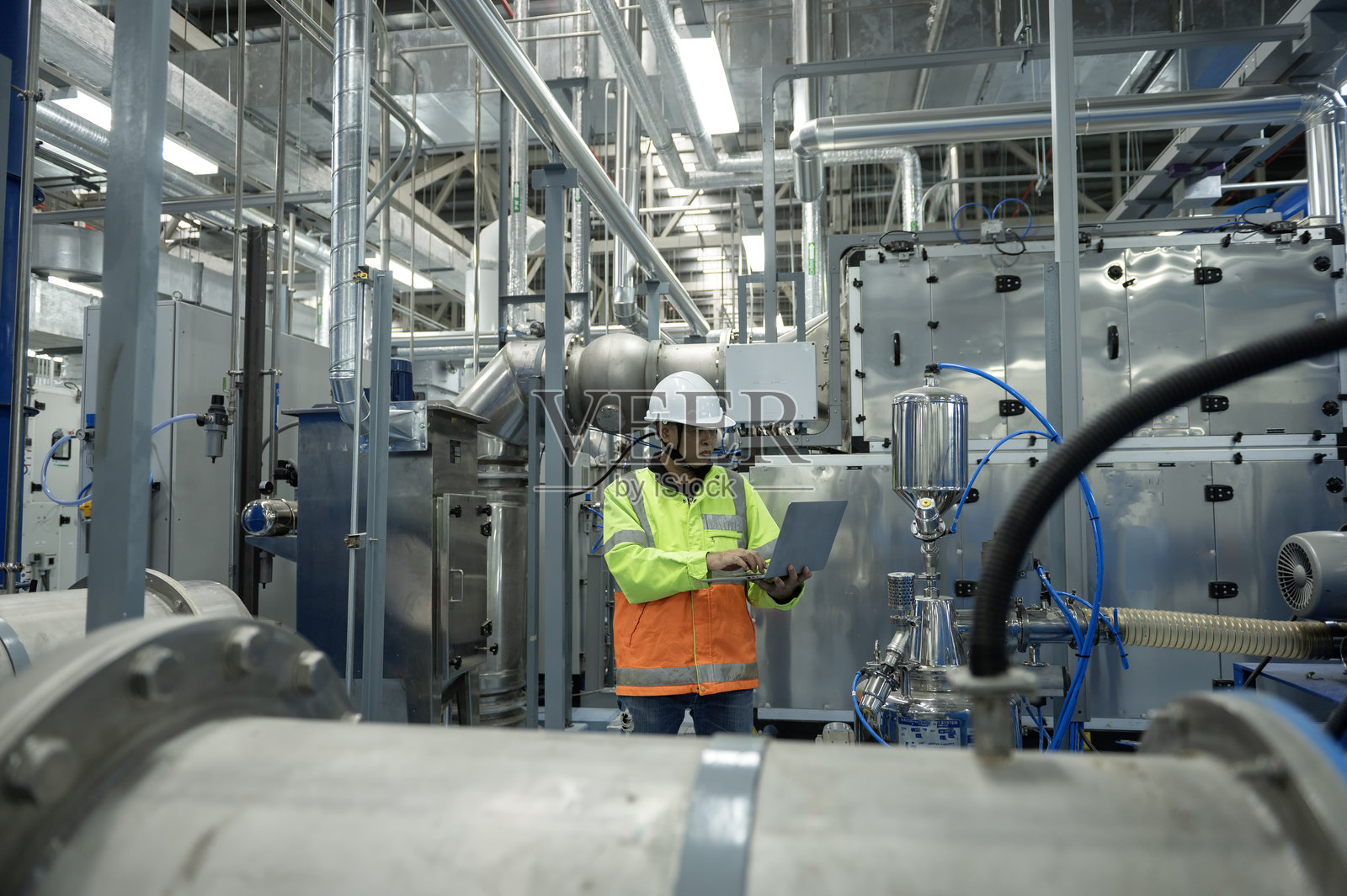 亚洲工程师在现代工业设施中进行管道系统检查照片摄影图片