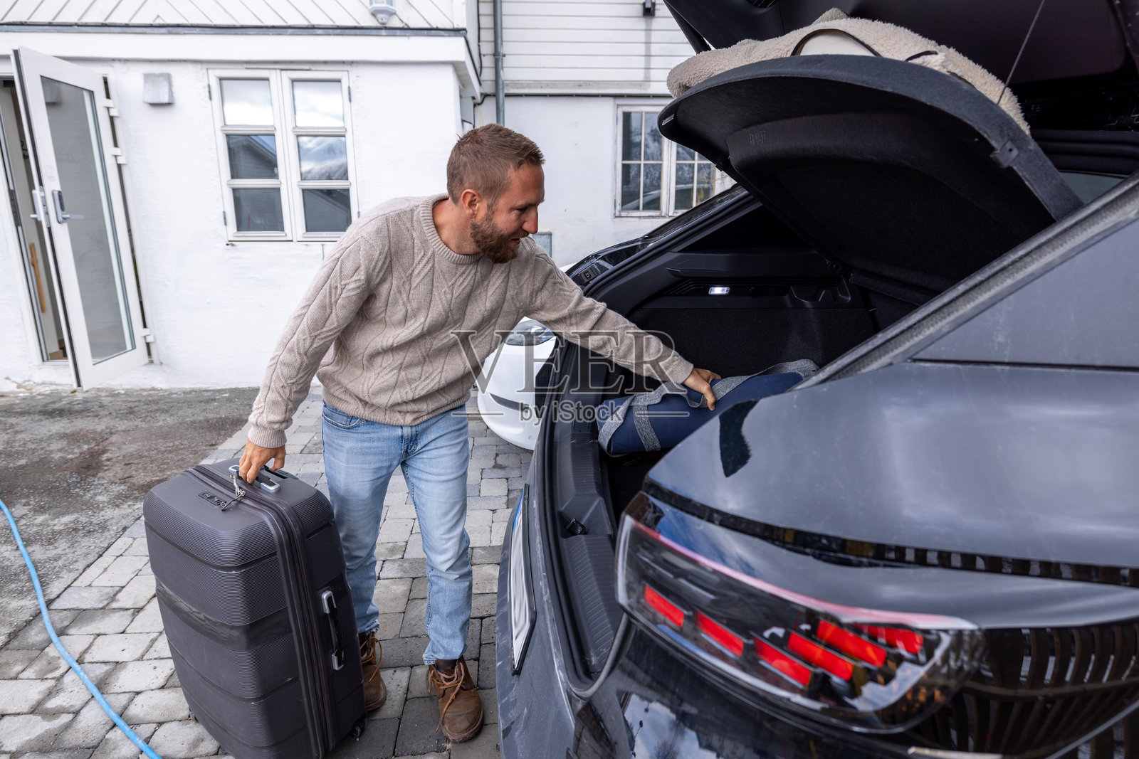 男子将行李装入汽车后备箱准备旅行照片摄影图片