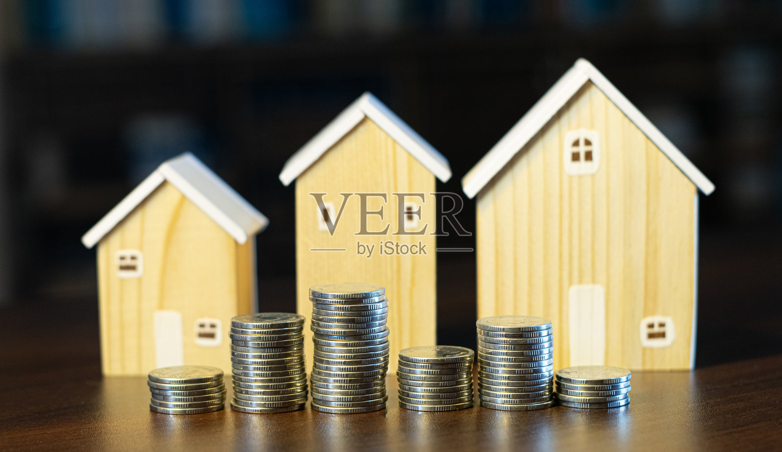木屋与堆叠的硬币，房屋买卖和获利的投资概念照片摄影图片