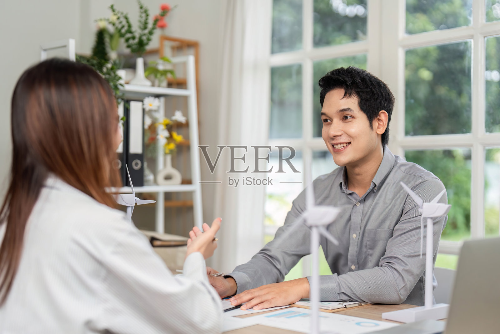 ESG咨询会议。商业专业人士与风能模型一起头脑风暴可持续解决方案。照片摄影图片