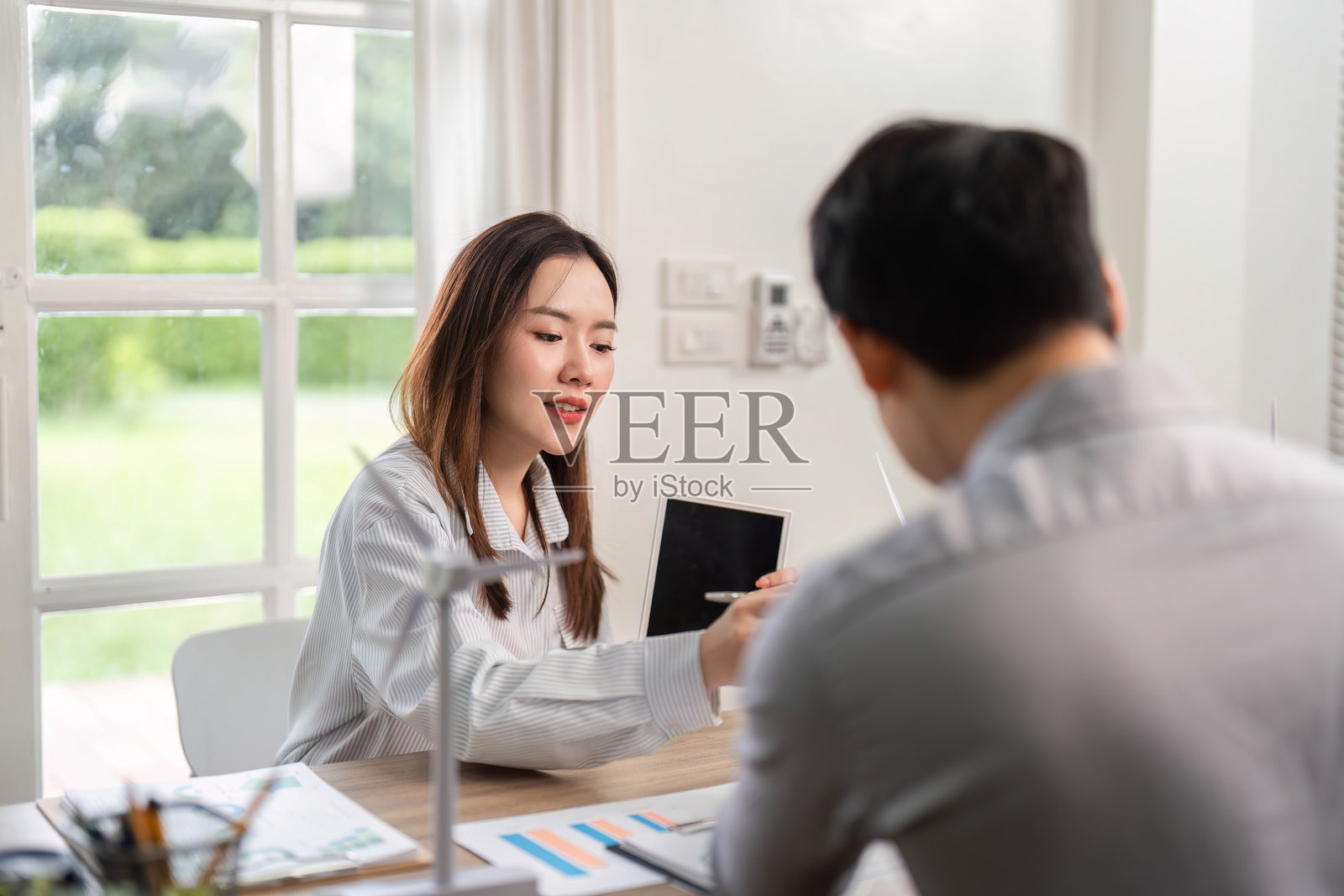 专注于ESG的商业讨论。女性在公司会议中使用平板电脑展示可持续发展理念。照片摄影图片