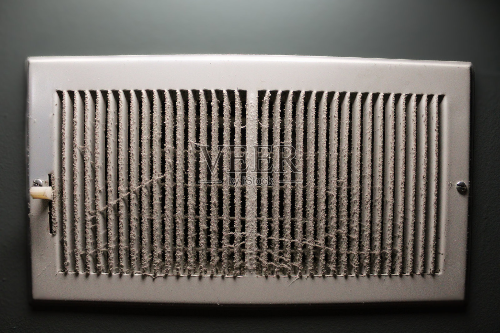 灰尘覆盖的回风格栅通风口特写。粉末涂层钢表面。是室内墙壁整体空气通风系统的一部分。照片摄影图片