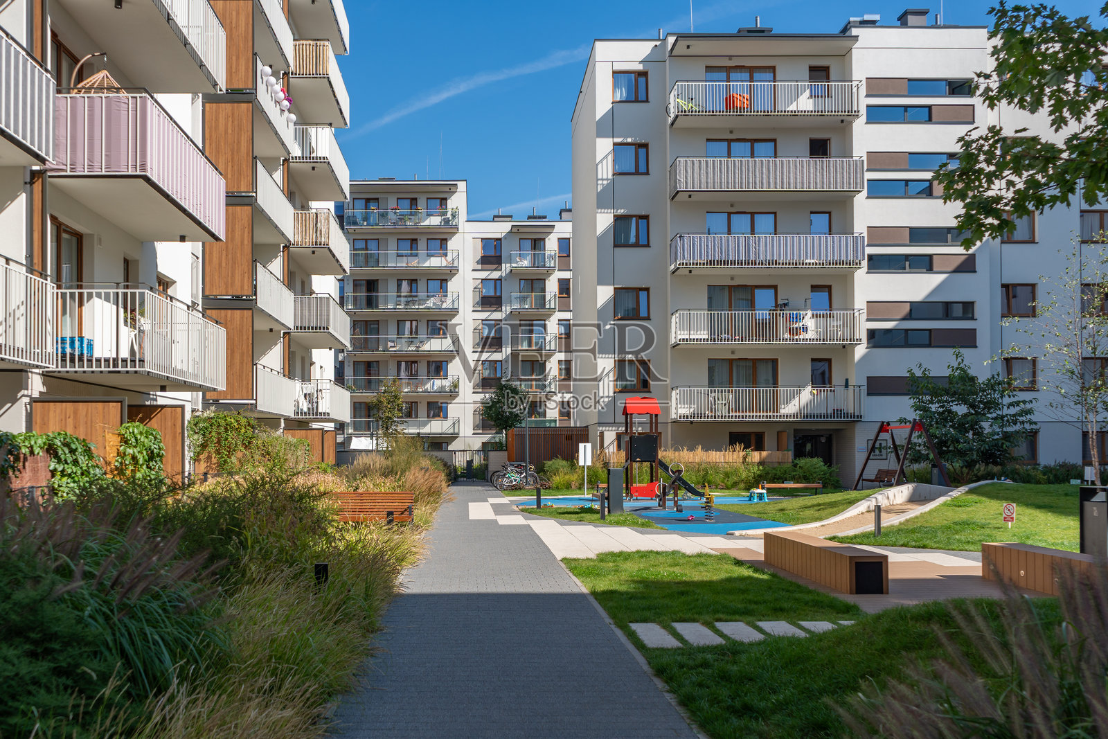 现代住宅区的社区空间，配有游乐场和长椅照片摄影图片