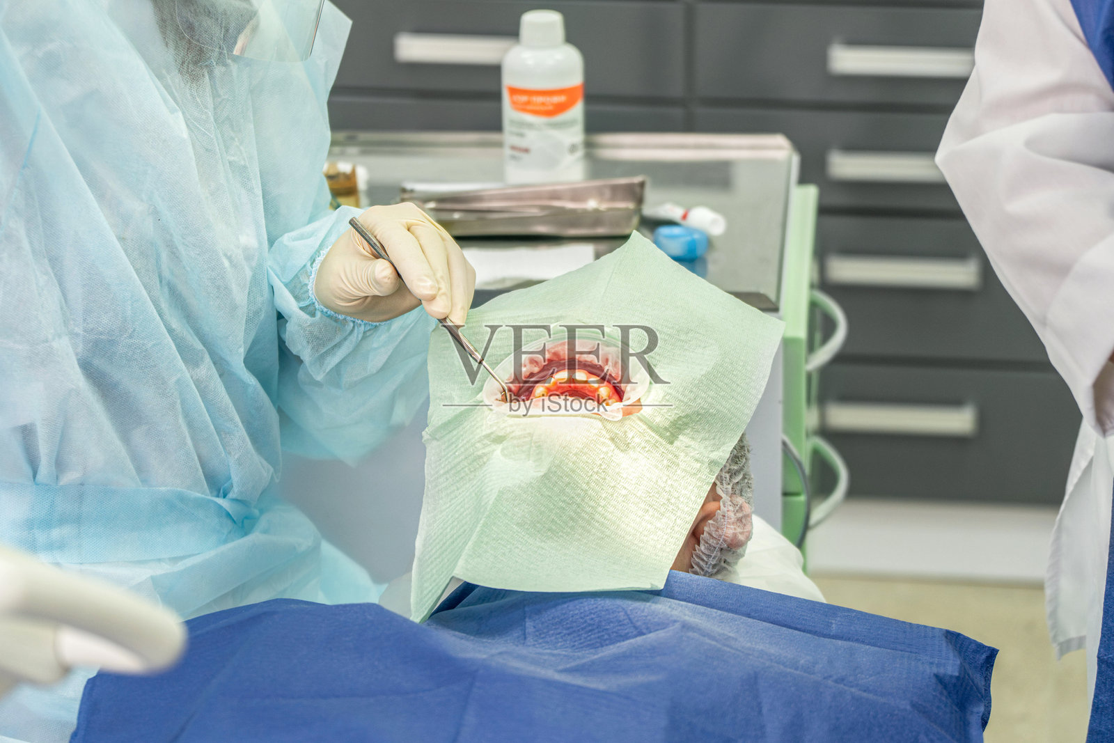 现代诊所环境中，医疗专业人员使用工具进行牙科手术照片摄影图片