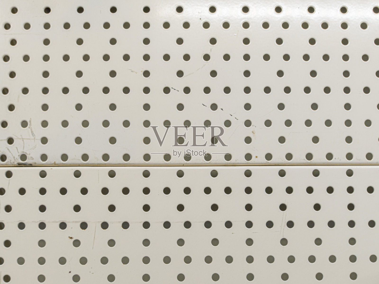 白色打孔板，均匀分布的孔用于在车间或车库中整理工具和材料照片摄影图片