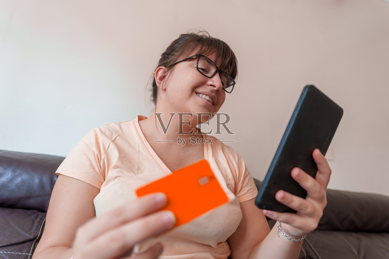 年轻女性在家中使用信用卡和平板电脑进行在线购物照片摄影图片