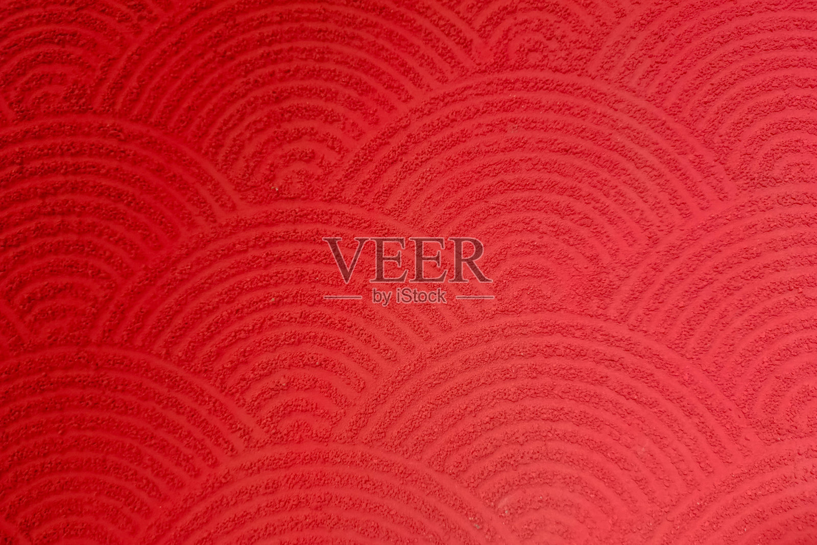 红色纹理表面，带有重复的半圆波浪图案，类似于传统日本图案。照片摄影图片
