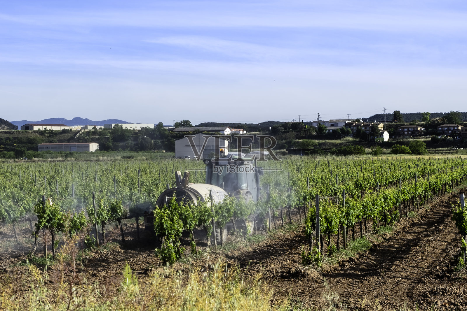 拖拉机在田地里喷洒农药照片摄影图片