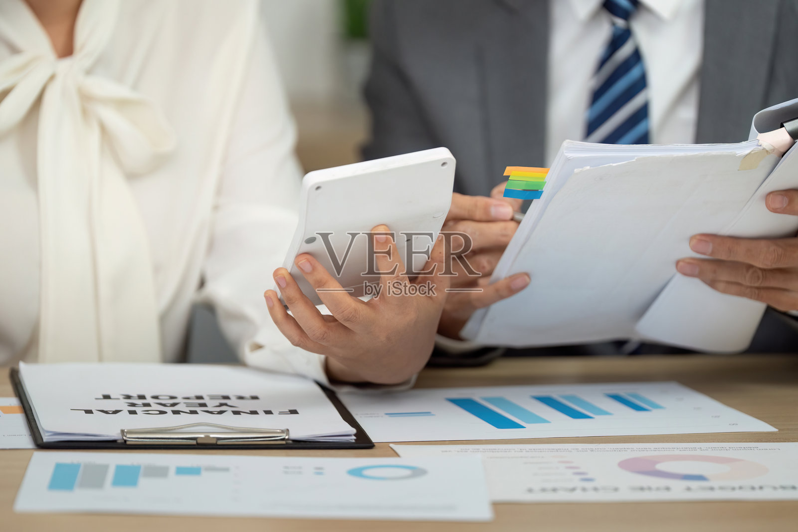 协作财务审查。专业人士在讨论财务报告时使用数字设备的特写。照片摄影图片