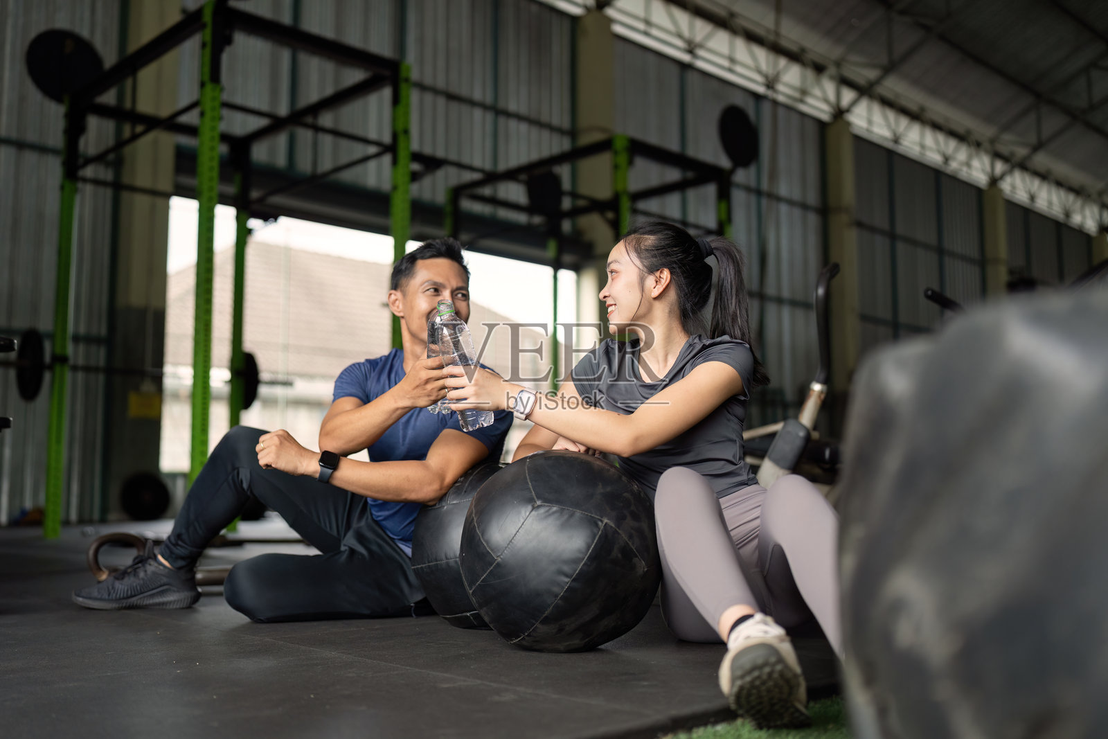 友谊与健身。朋友们在健身房锻炼后享受水分补给的时光。照片摄影图片
