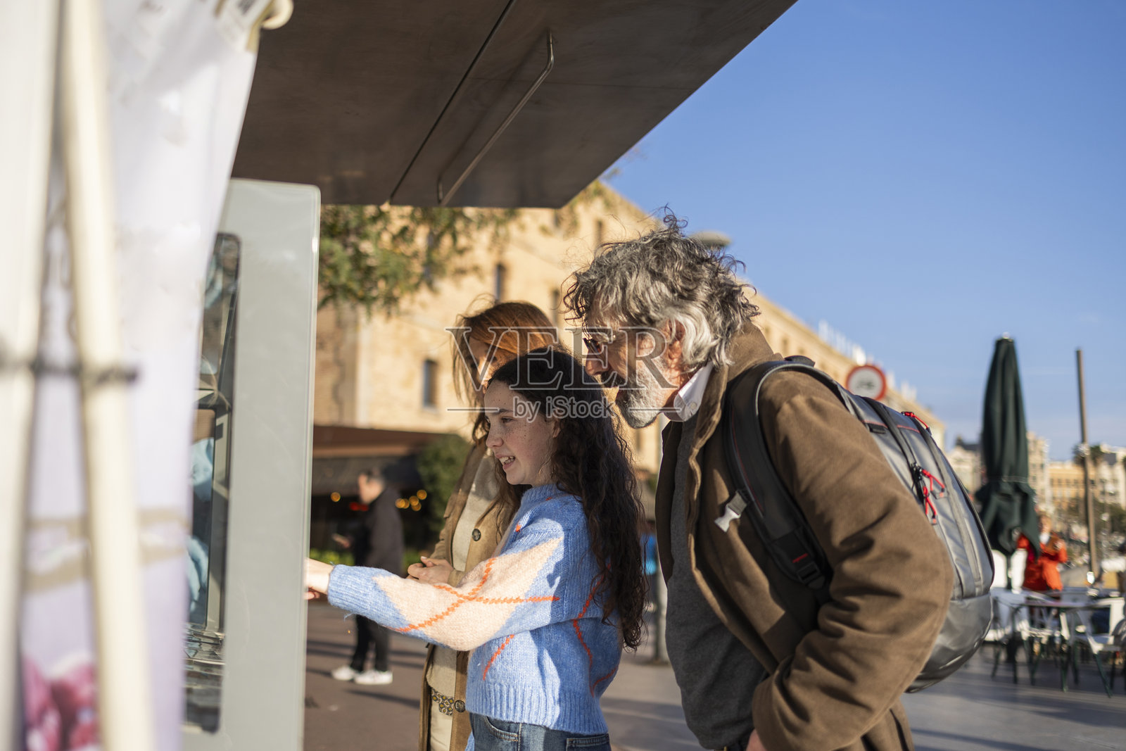 一家人在西班牙马略卡岛的互动自助终端前使用。照片摄影图片
