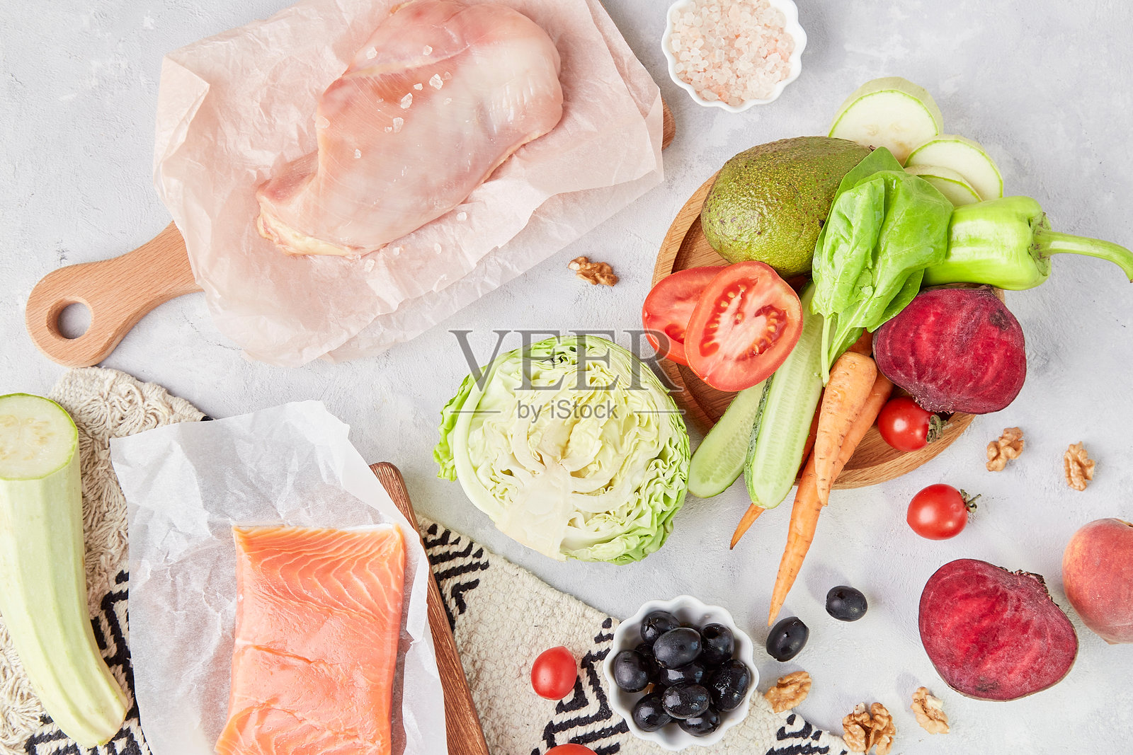 生酮、低FODMAP、古饮食、低碳水化合物饮食概念 - 木质切菜板上的蔬菜、鸡肉、三文鱼和绿叶蔬菜的俯视图照片摄影图片