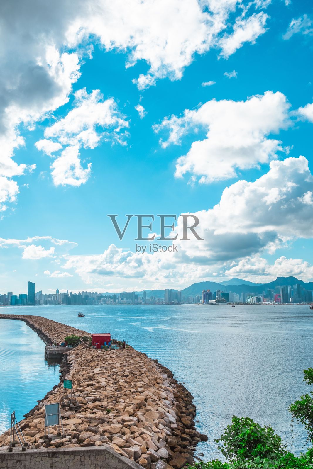 风景如画的岩石码头，背景是城市天际线和蓝天。照片摄影图片