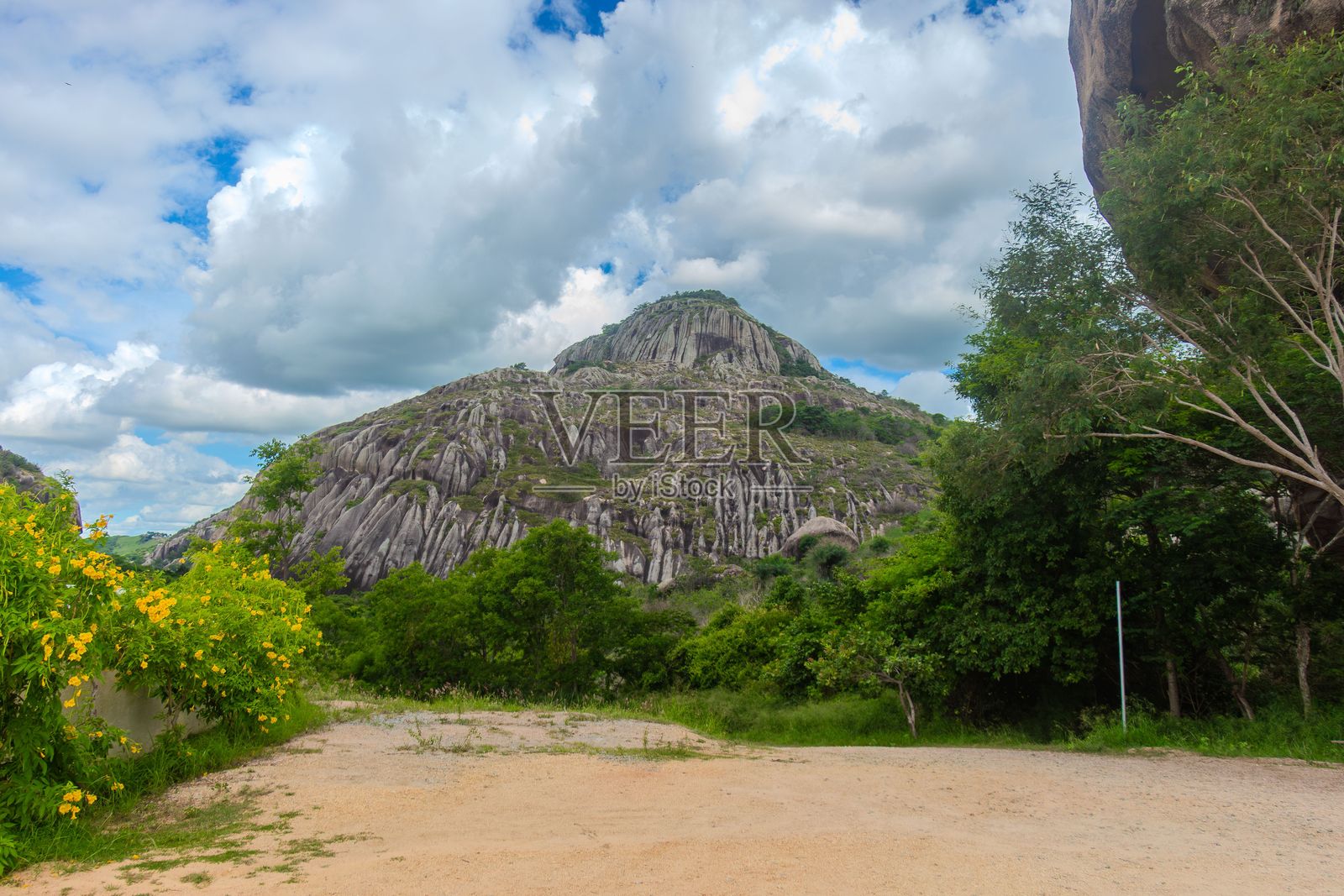岩石山丘与阴云密布的绿树成荫景色照片摄影图片