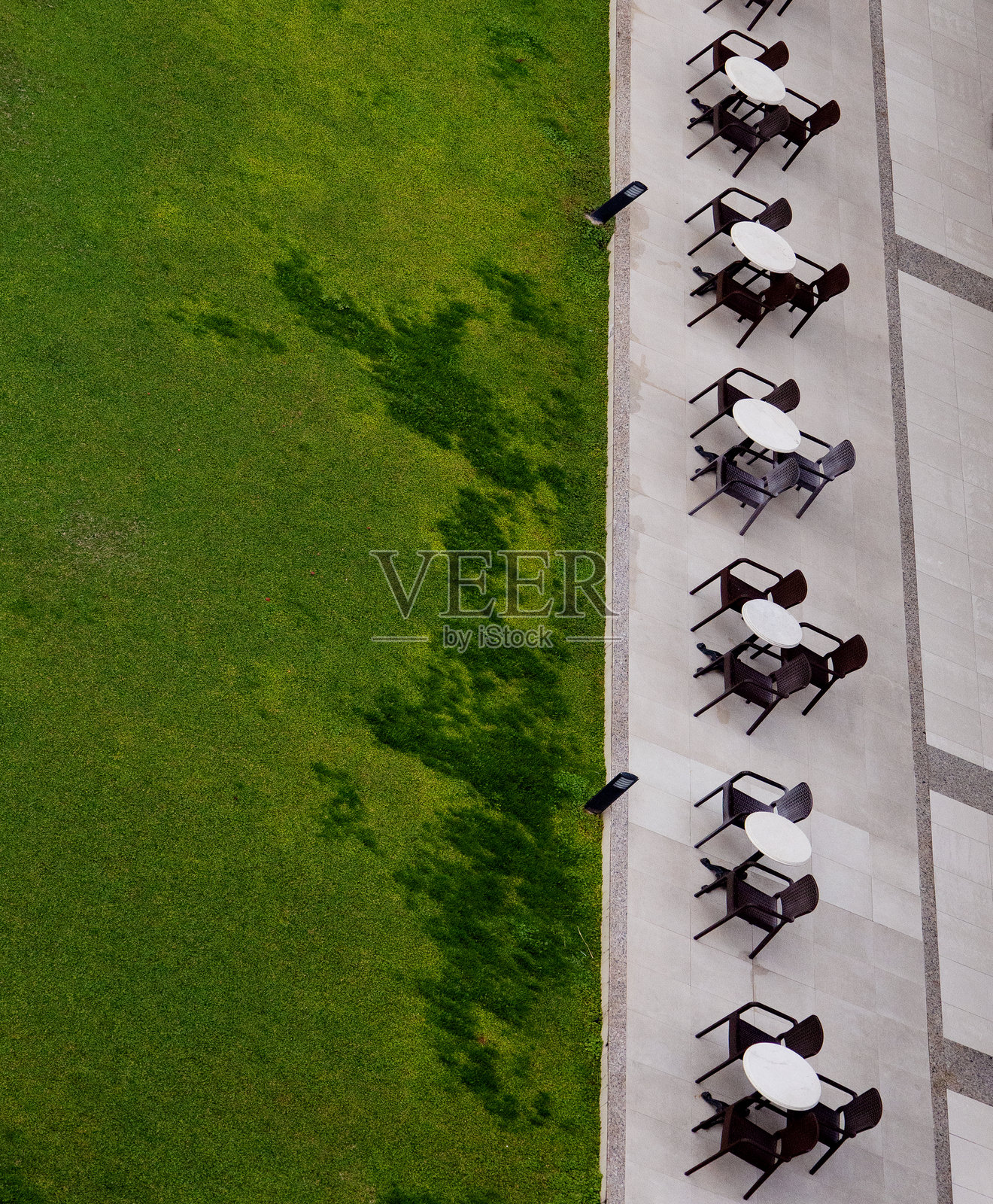 户外咖啡馆的桌子从上方俯瞰，绿草如茵，竖版。照片摄影图片