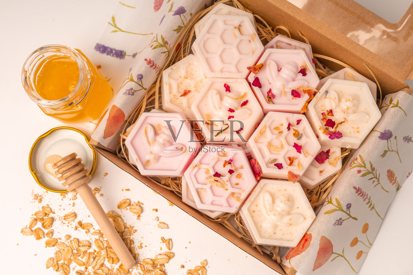 手工制作的小蜂窝燕麦和蜂蜜香皂条，装在盒子里。美观的香皂在白色背景上，留有空白空间。照片摄影图片