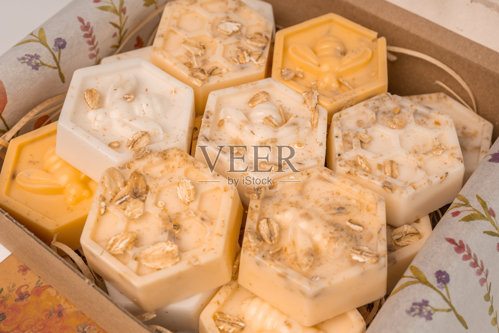 手工制作的小蜂窝燕麦和蜂蜜香皂条，装在盒子里。美观的香皂在白色背景上，留有空白空间。照片摄影图片