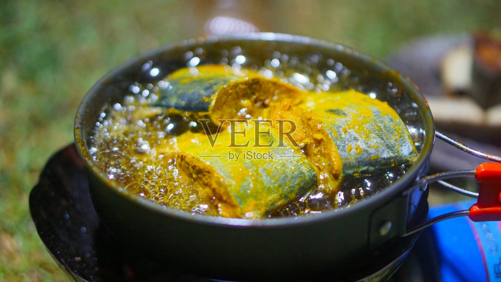 在便携式煤气炉上煎炸巴拉库达鱼（拉丁名：Sphyraena putnamae）。照片摄影图片