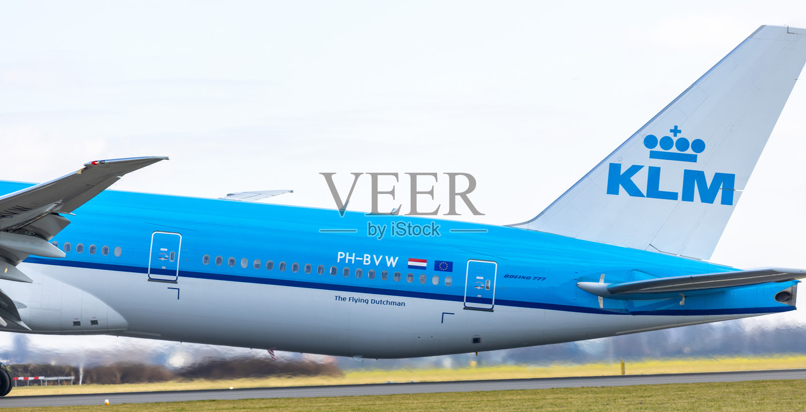 KLM飞机在跑道上起飞的特写,蓝色背景照片摄影图片