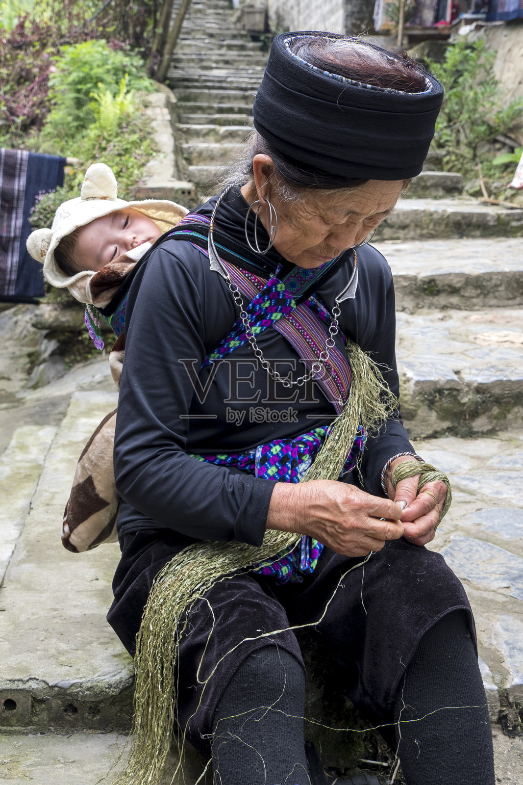 在越南沙巴的卡卡村，一位老年妇女背着婴儿。照片摄影图片