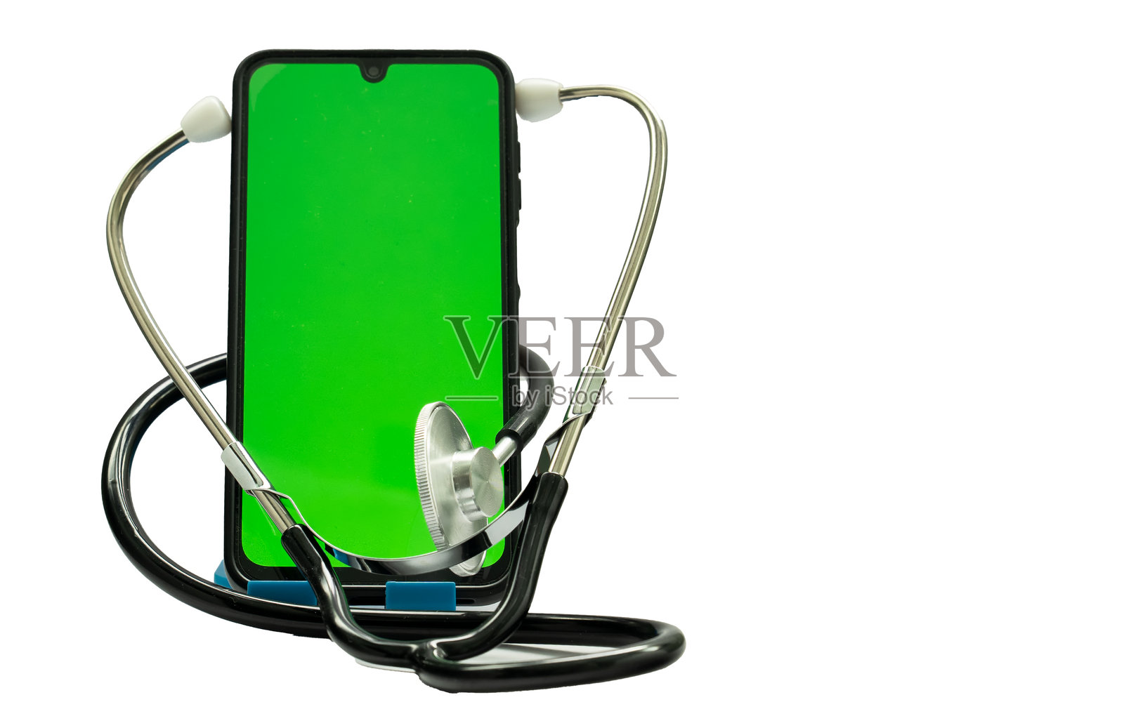 智能手机上有绿色抠像屏幕，周围缠绕着听诊器，暗示在线医疗咨询或远程医疗服务。照片摄影图片