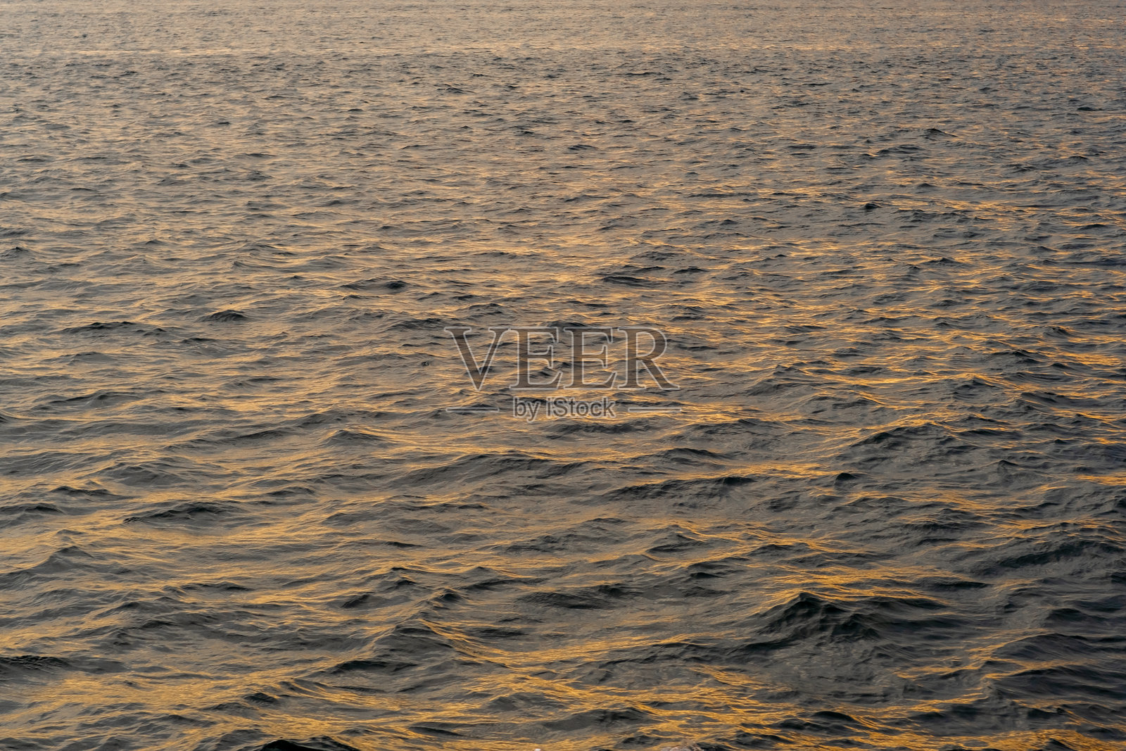 博斯普鲁斯海峡在日落时分金色光芒下闪烁的水面，展现出宁静的美丽，映衬着平静的傍晚。照片摄影图片