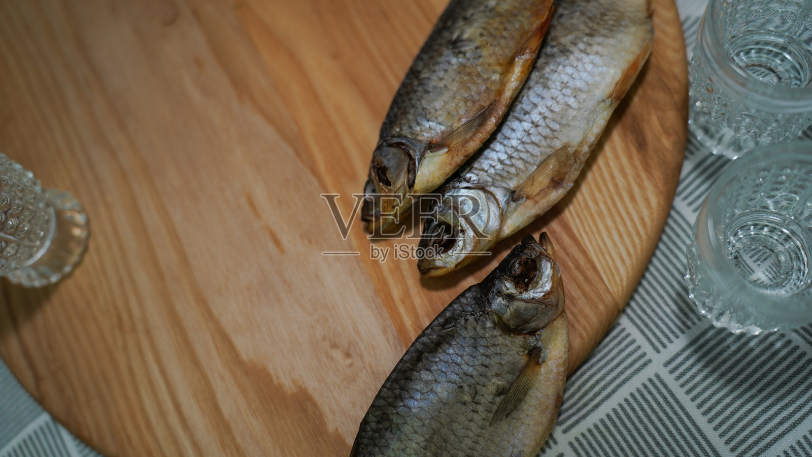 桌子上的传统干鱼和几杯伏特加照片摄影图片