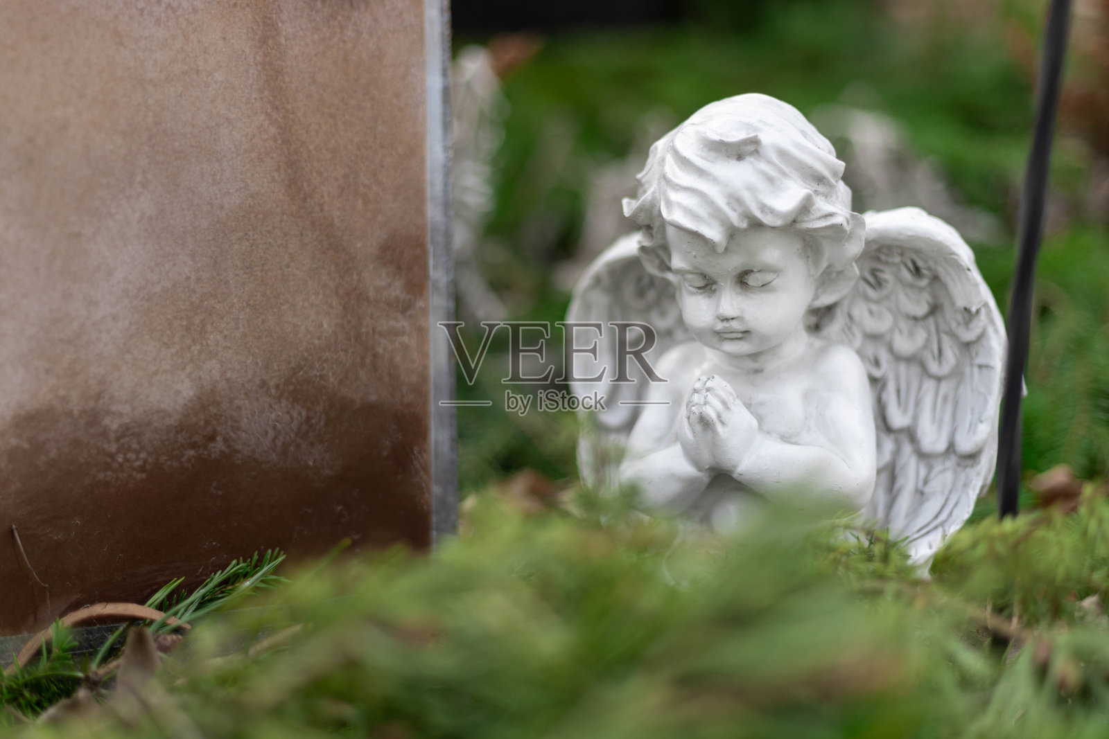 芬兰一个宁静的路德教墓地，孤独的墓碑上矗立着一座石制天使。周围环境宁静，散发着一种安静而尊重的氛围。照片摄影图片