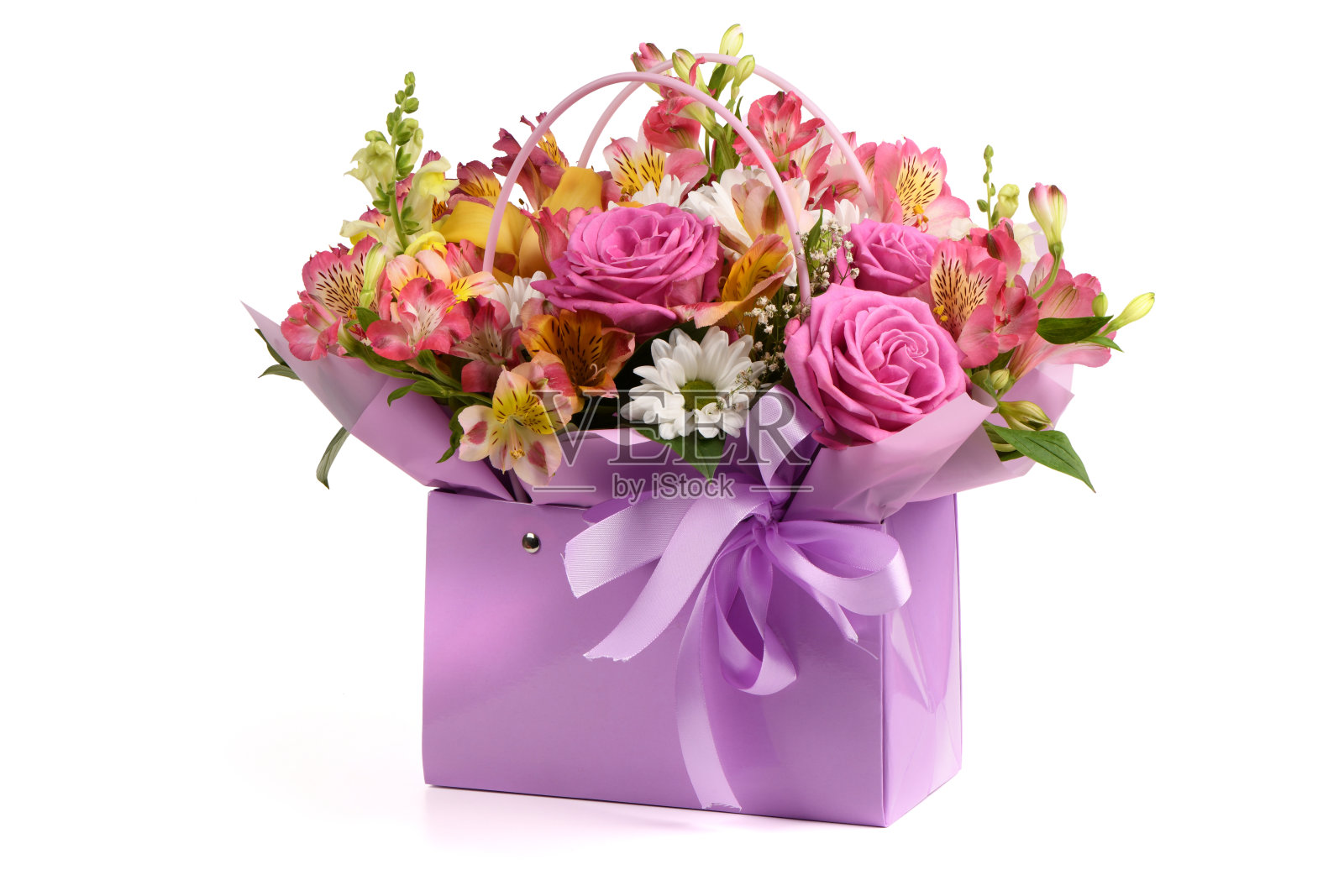 一束花和一个带手柄的紫色包，白色背景。花束包括菊花、玫瑰、百合和康乃馨。照片摄影图片