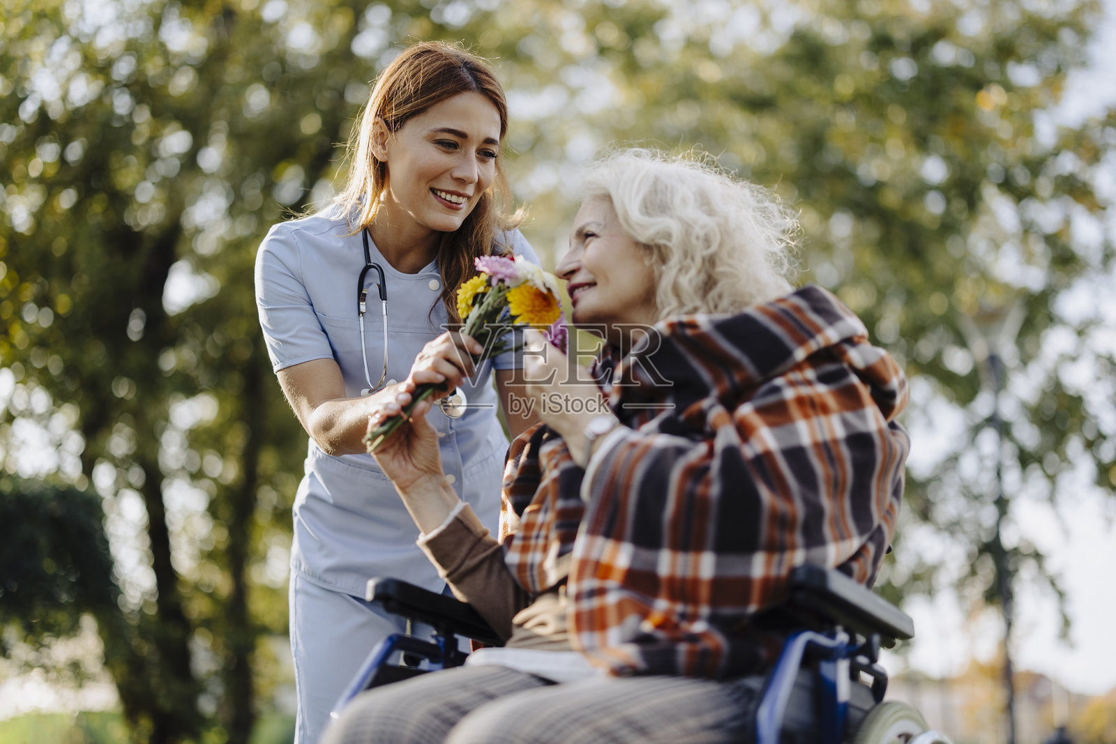 一位坐在轮椅上的老年女性正在接受护士的照顾照片摄影图片