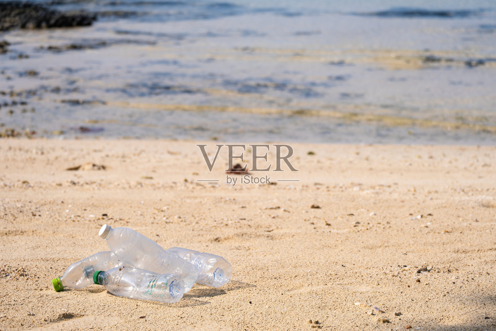 海滩垃圾，塑料杯和塑料袋。海洋垃圾是全球主要的环境问题之一。照片摄影图片