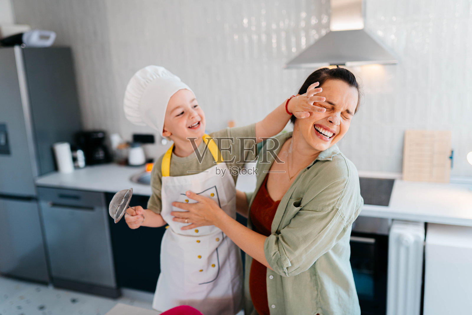 可爱的小厨师和他的妈妈照片摄影图片