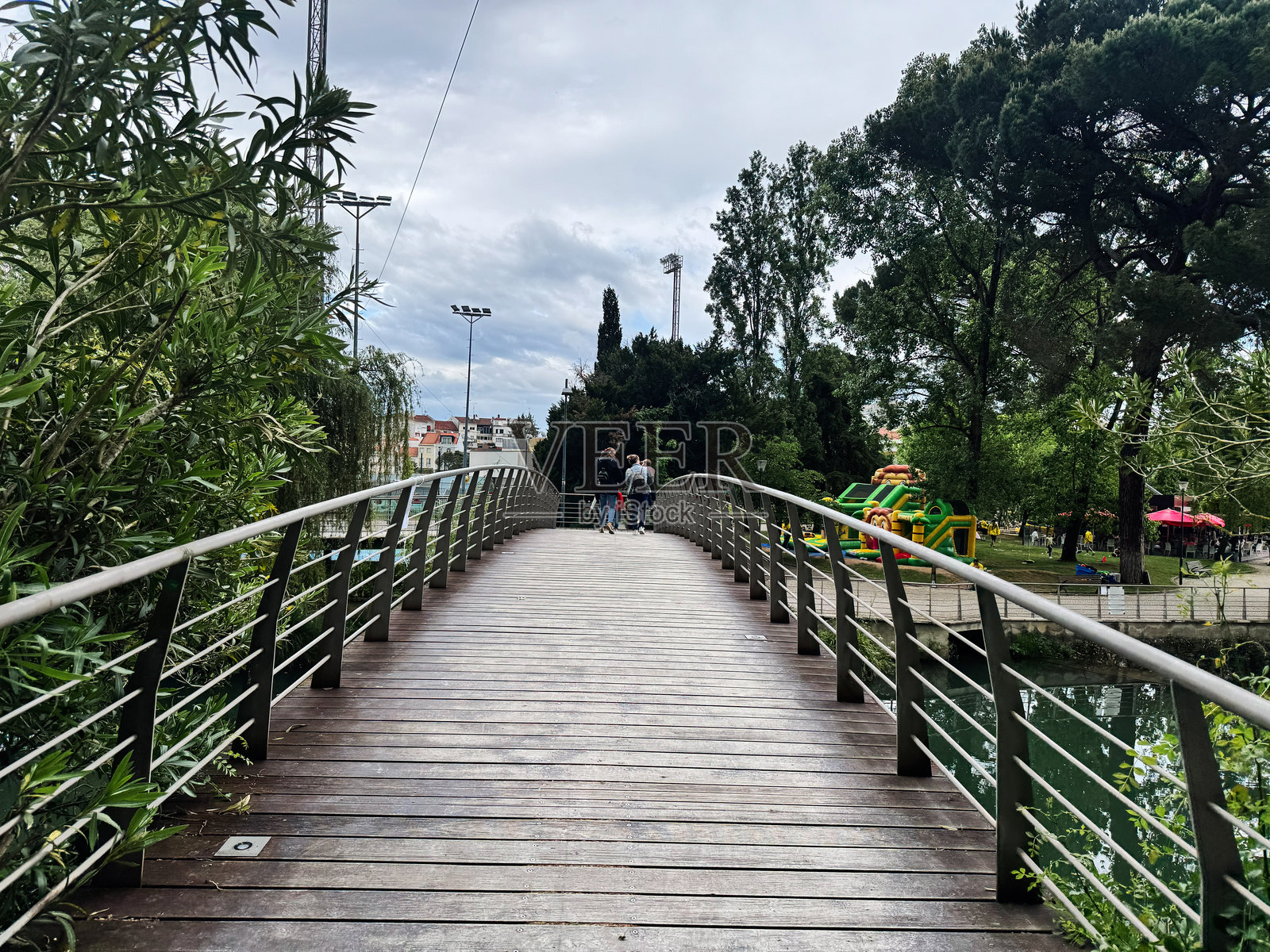 汤玛尔公园内风景如画的人行桥，周围环绕着郁郁葱葱的绿树。照片摄影图片