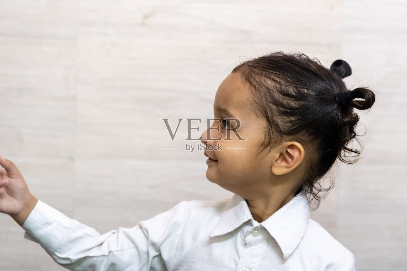 室内穿着衬衫的印度小孩可爱的面部表情照片摄影图片