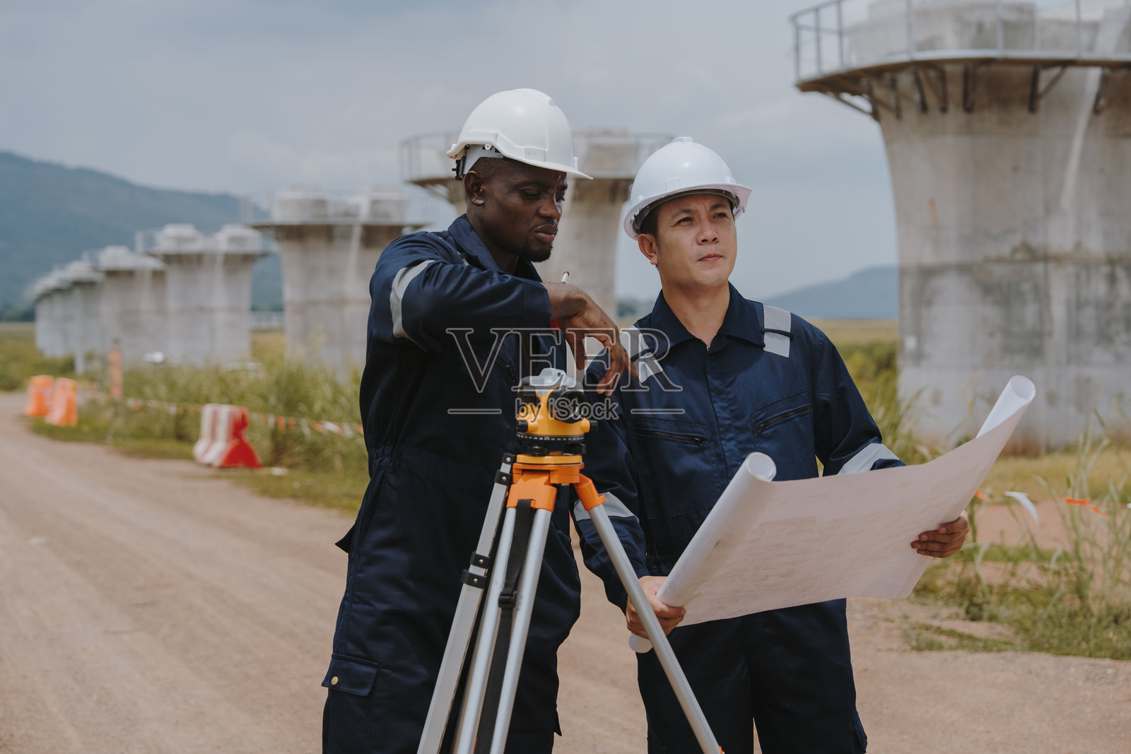 土木测量工程师在公路和高速铁路施工现场使用测量相机进行测量或进行安全检查。照片摄影图片