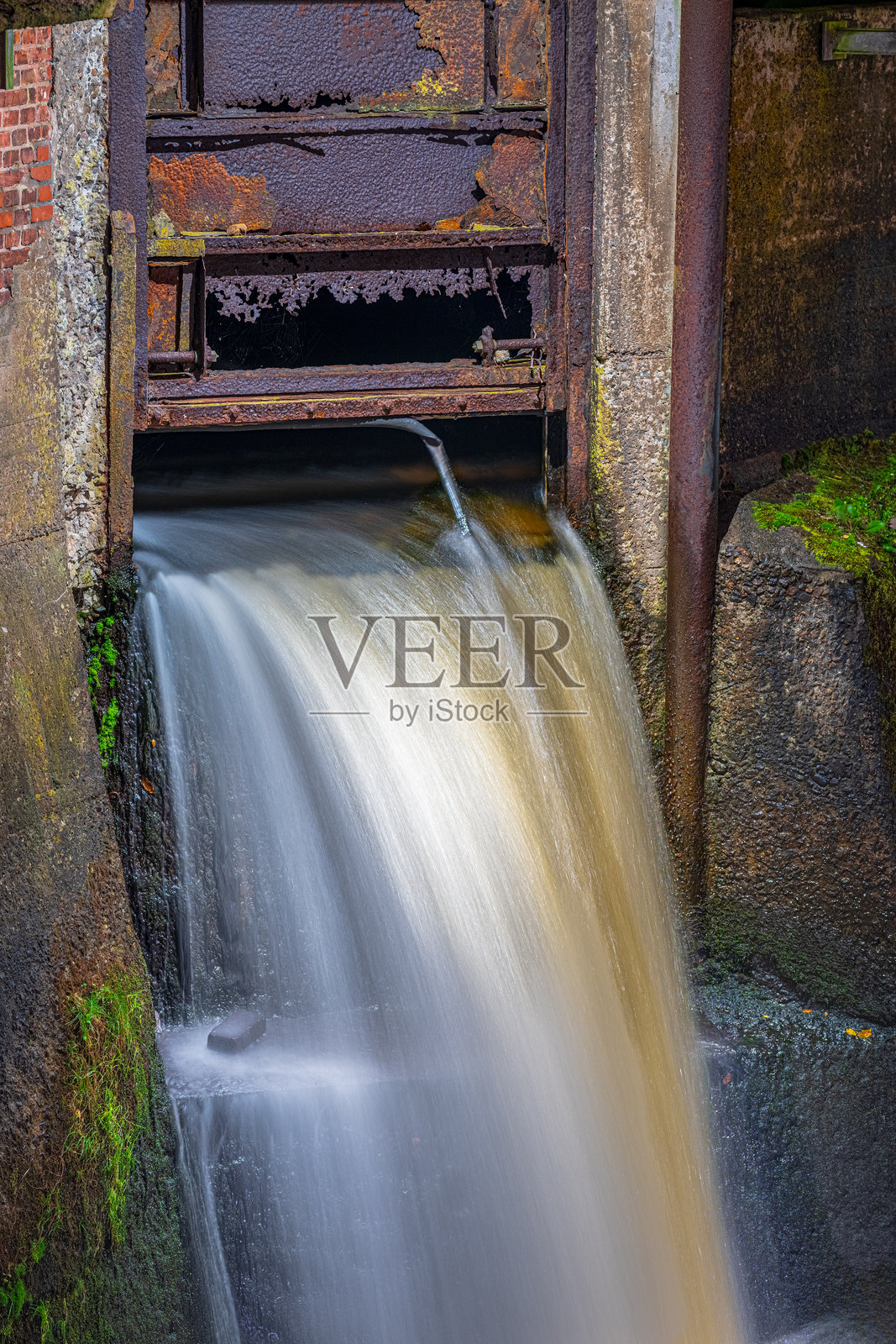 生锈的工业水闸特写，水流潺潺。照片摄影图片