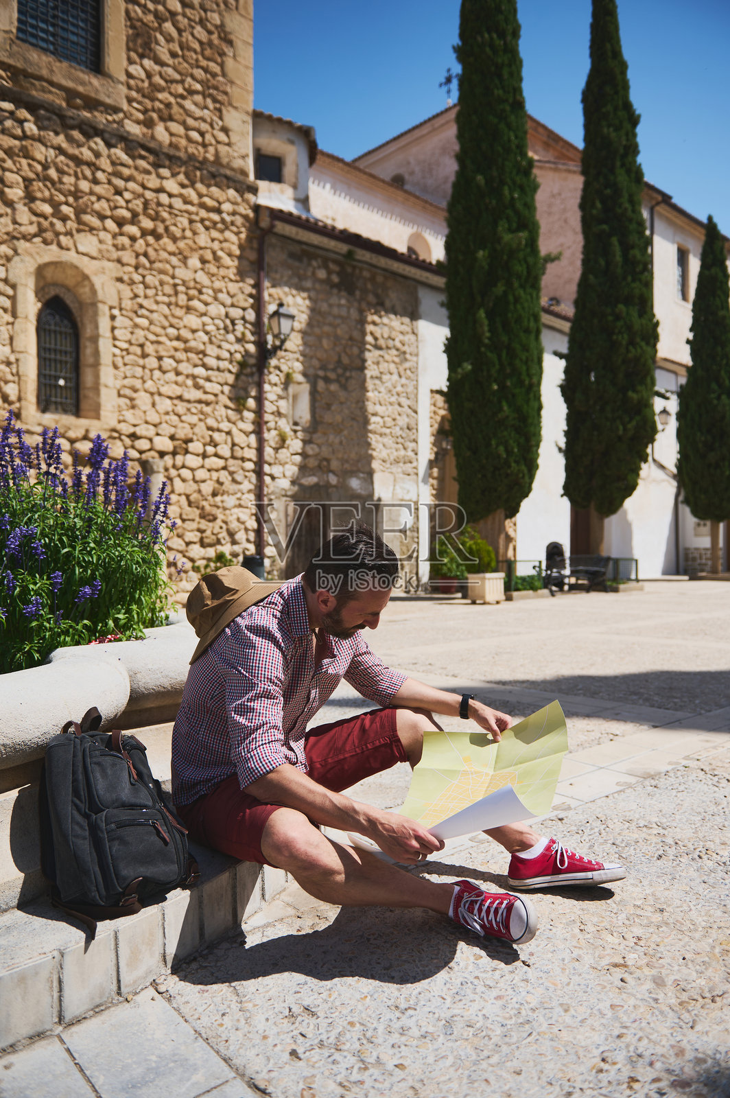 游客在阳光明媚的日子里，手持地图探索中世纪西班牙村庄照片摄影图片