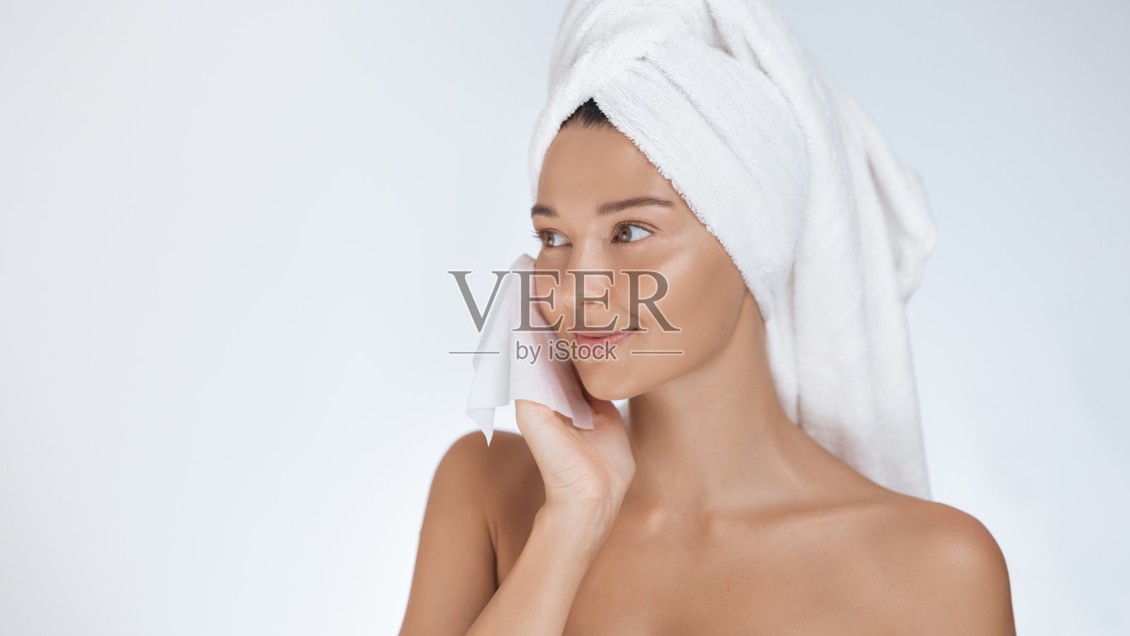 美丽的女人在清爽护肤后用毛巾擦干脸部照片摄影图片