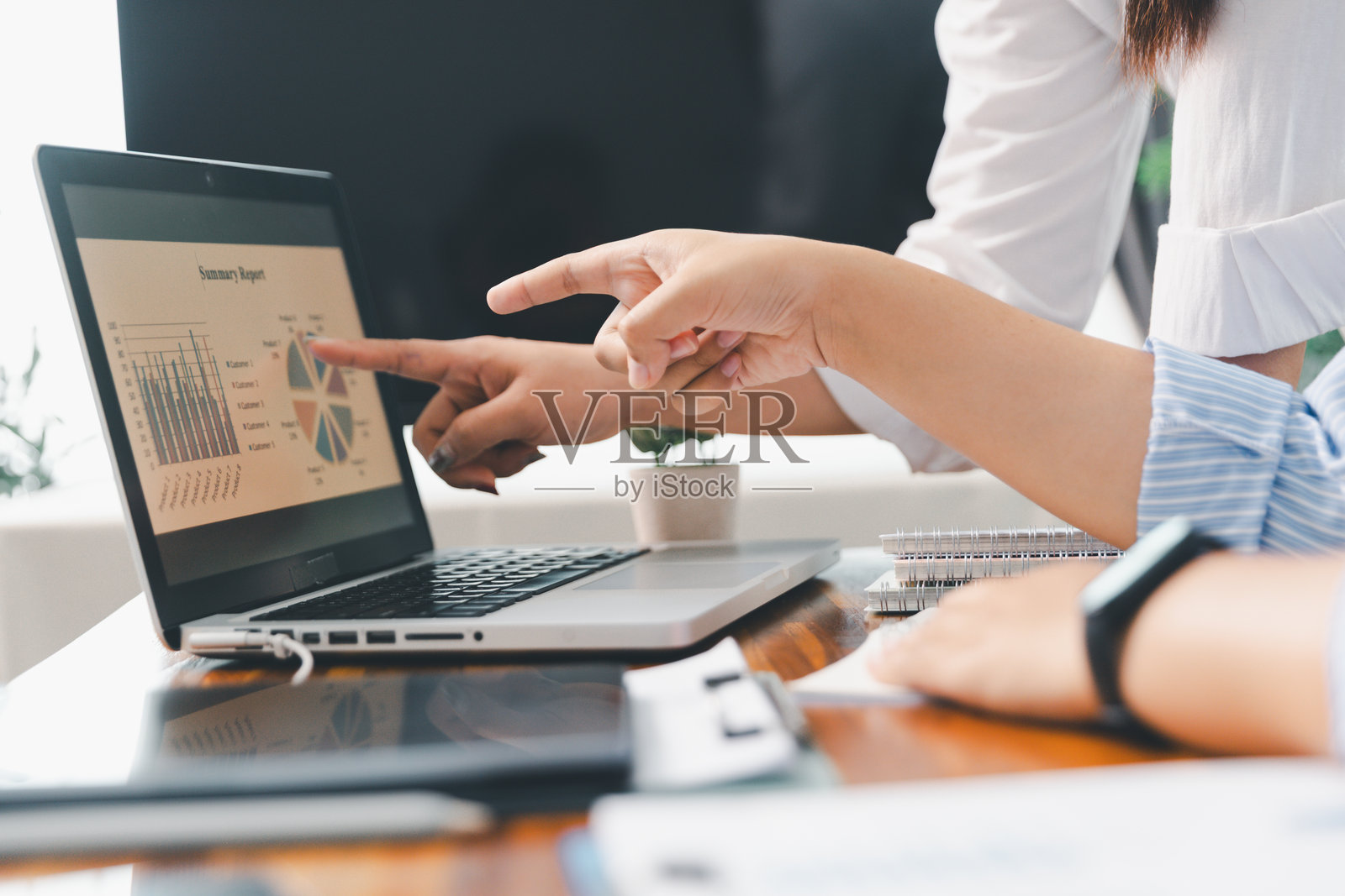 会议室内，商业人士团队合作分析桌上的成本图表。合作分析图表展示公司财务预算报告、成本工作进展规划及商业团队分析数据。照片摄影图片