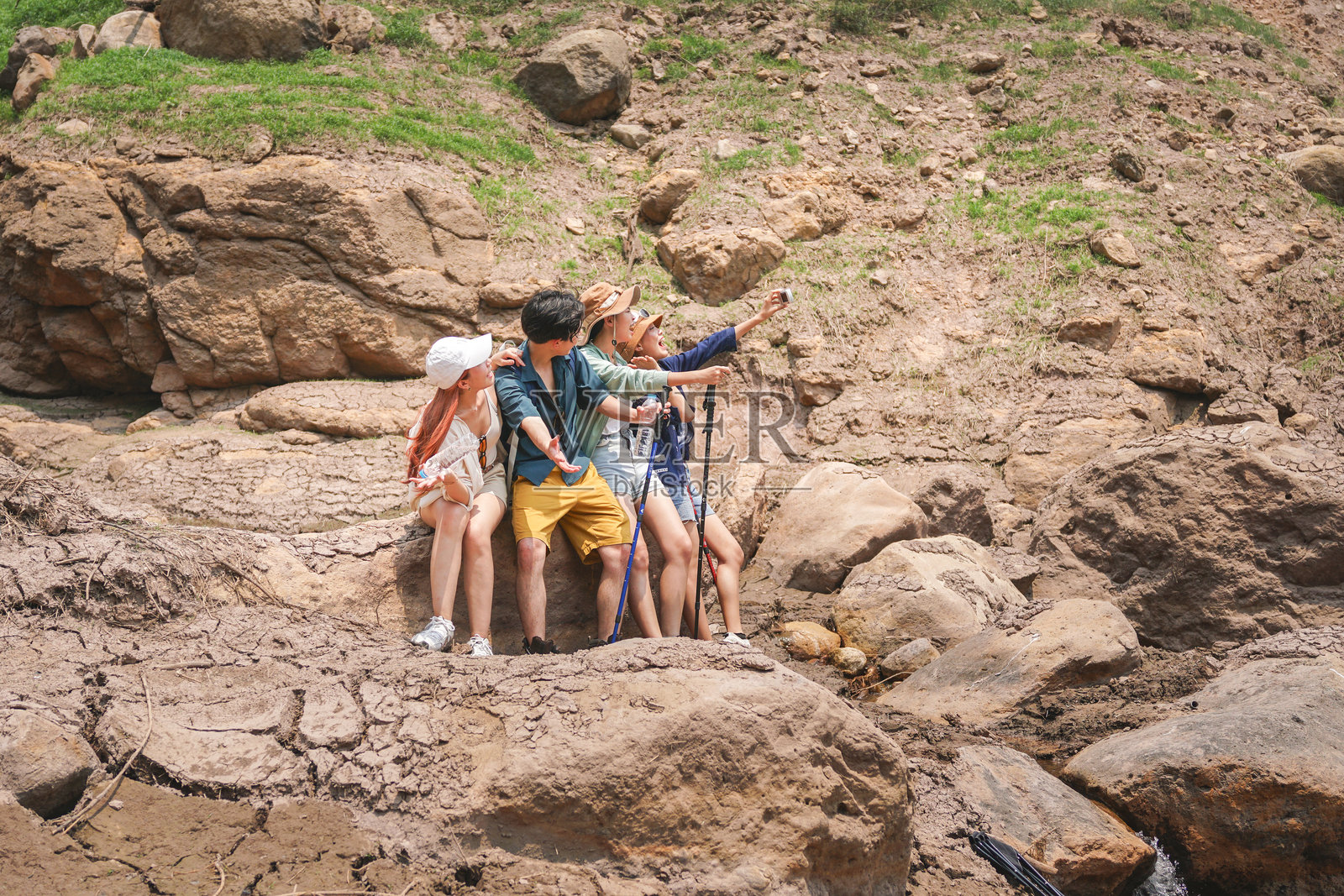 朋友们在岩石户外探险中自拍，一群徒步旅行者探索干燥的岩石景观，年轻人在夏日短途旅行中享受大自然。照片摄影图片